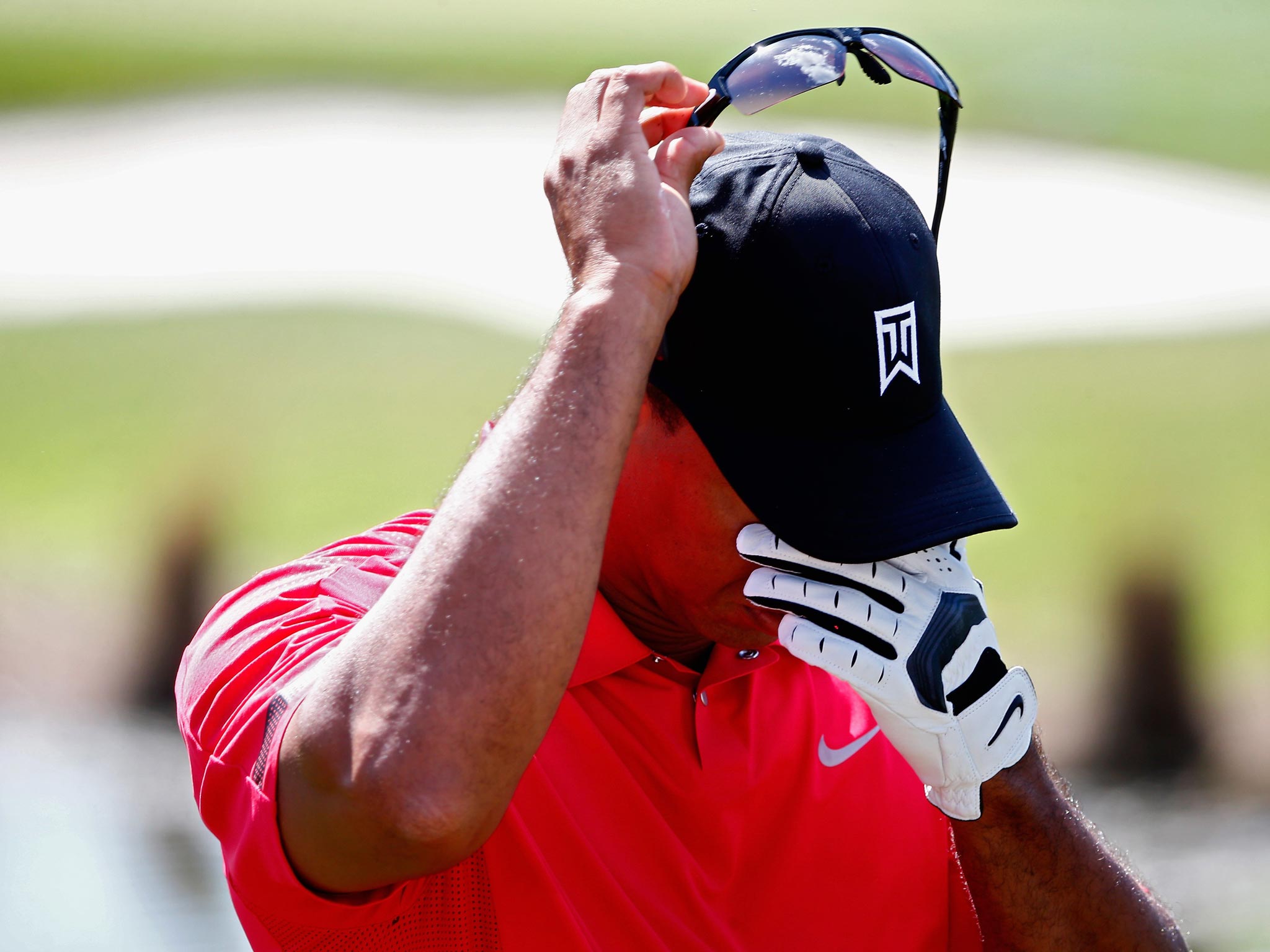 Tiger Woods grimaces with pain before his withdrawal from the Honda Classic