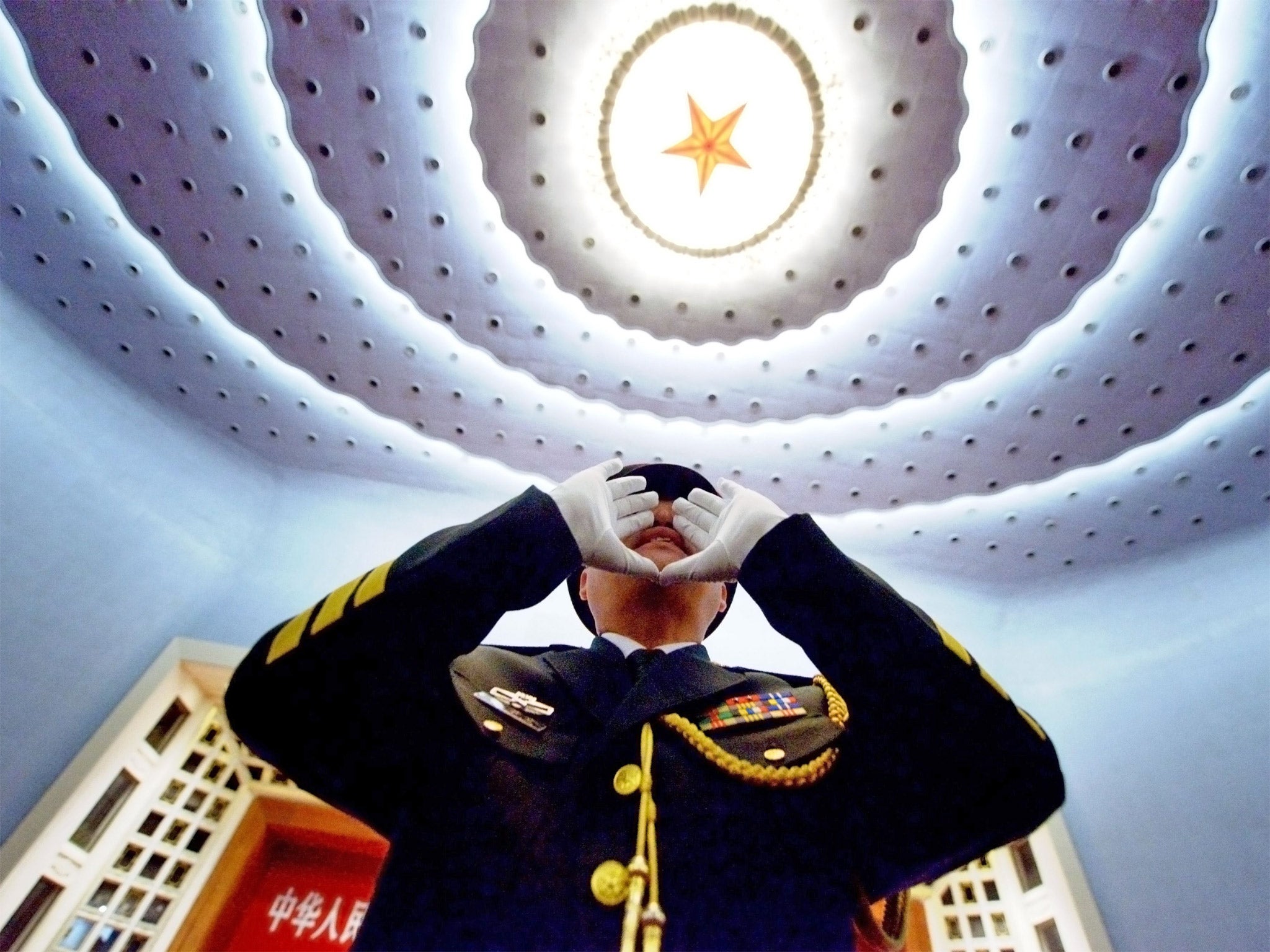 Top brass: an officer in the Chinese People’s Liberation Army practises to conduct the military band before the opening session of the 12th National People’s Congress in Beijing