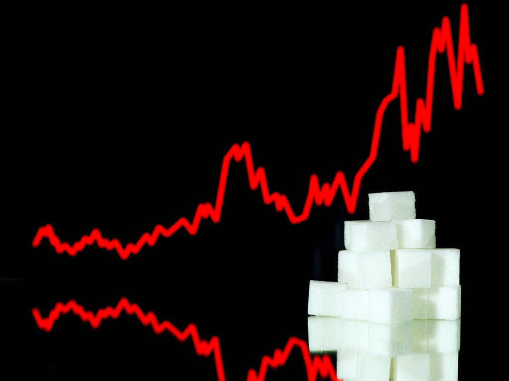 A picture taken on January 10, 2013 in Paris shows an illustration made with pieces of white sugar and a screen displaying the sugar exchange rate curve from 2002 to 2012.