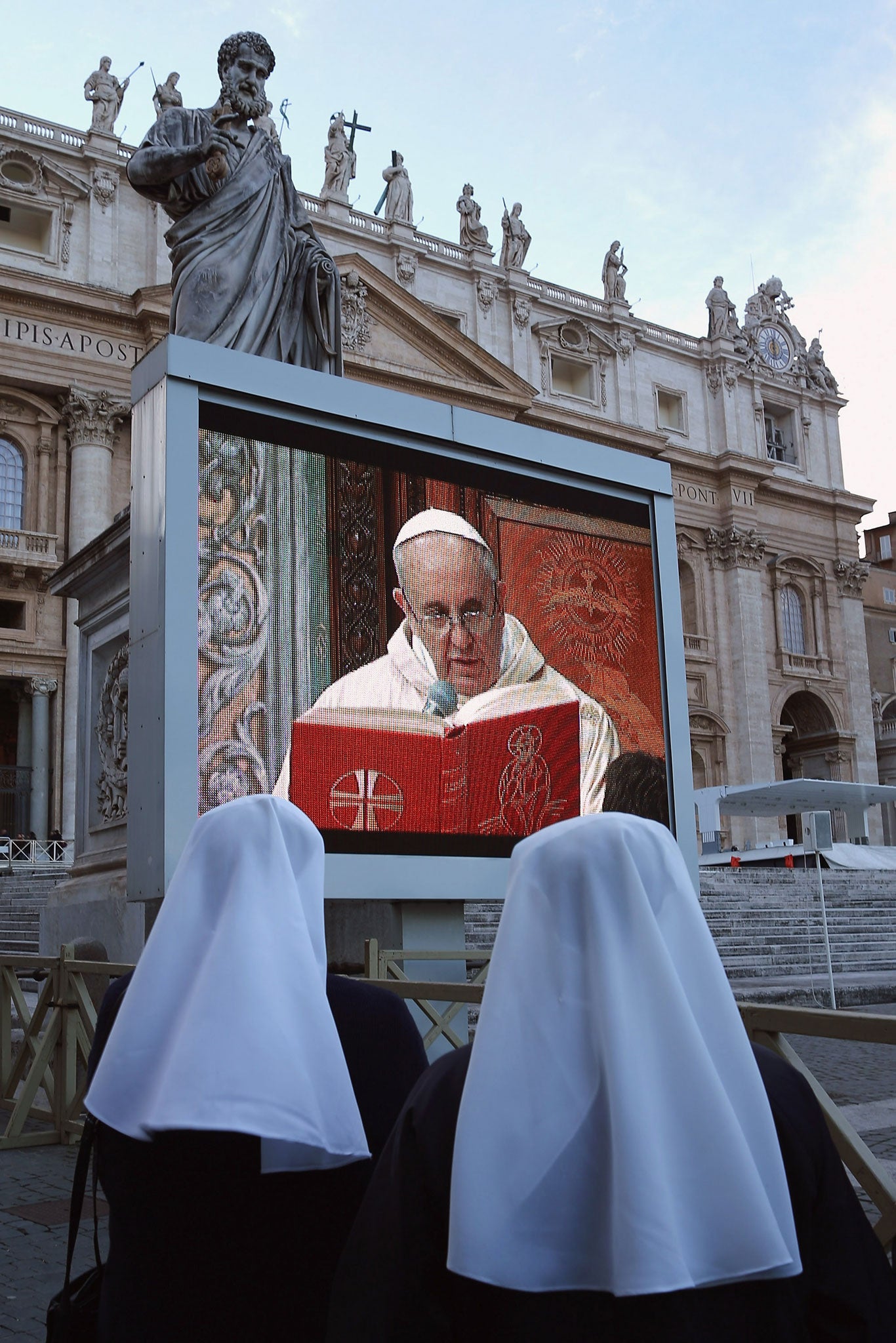 A screen beams the new Pope's Sistine Chapel Mass to those gathered in St Peter's Square