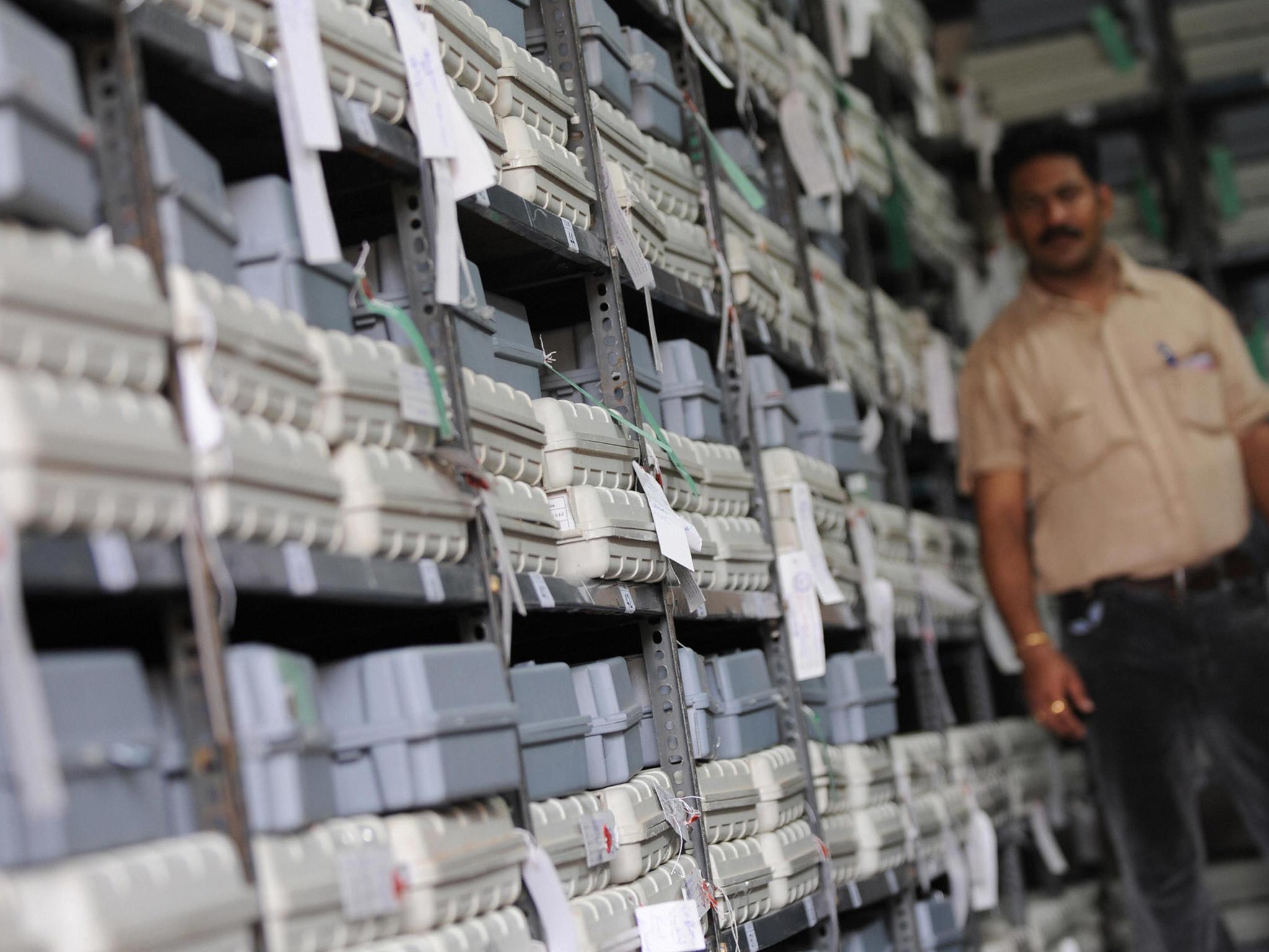 An Indian election official on duty guards electronic voting machines