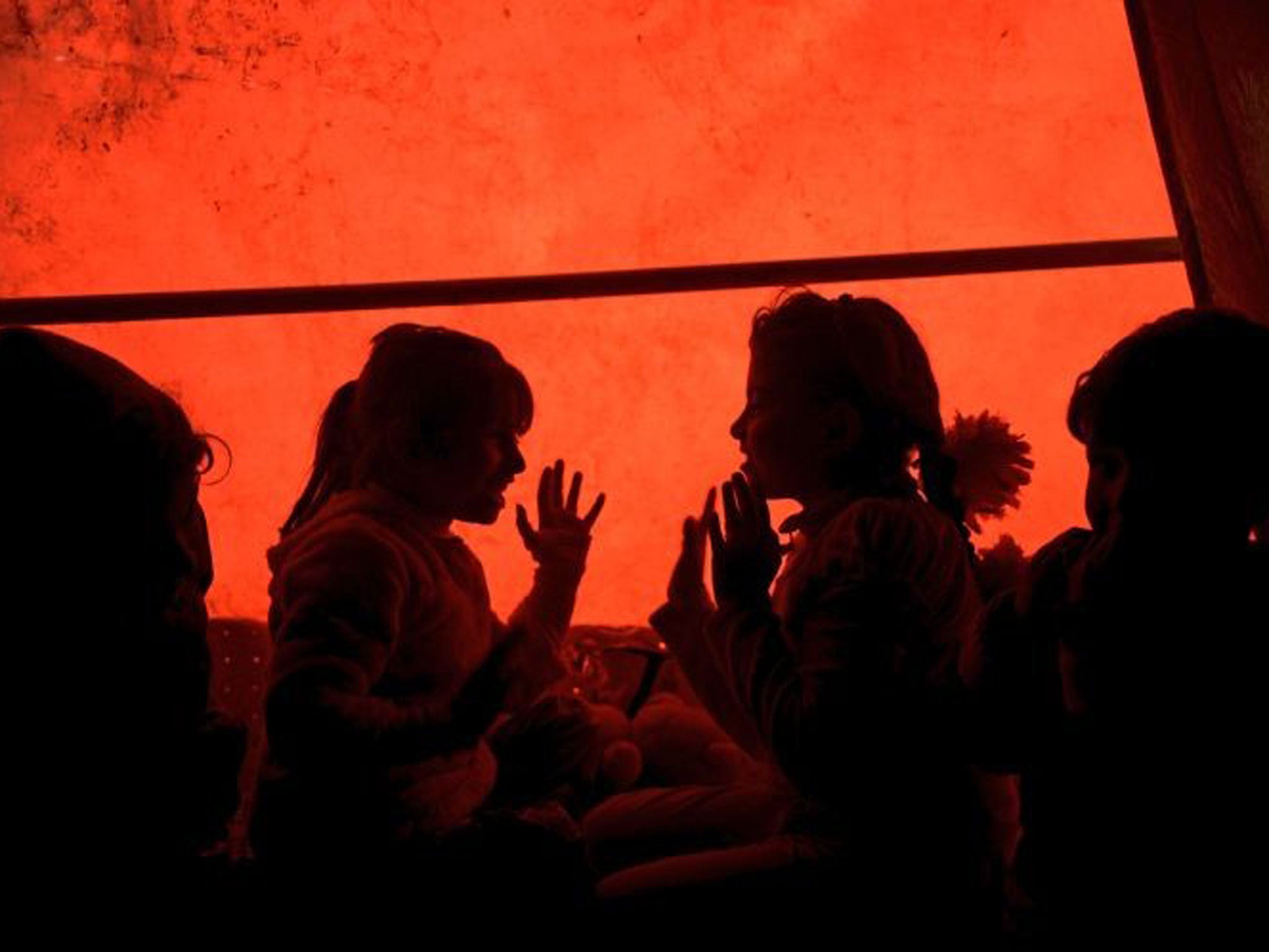 Two young Syrian girls play inside the camp