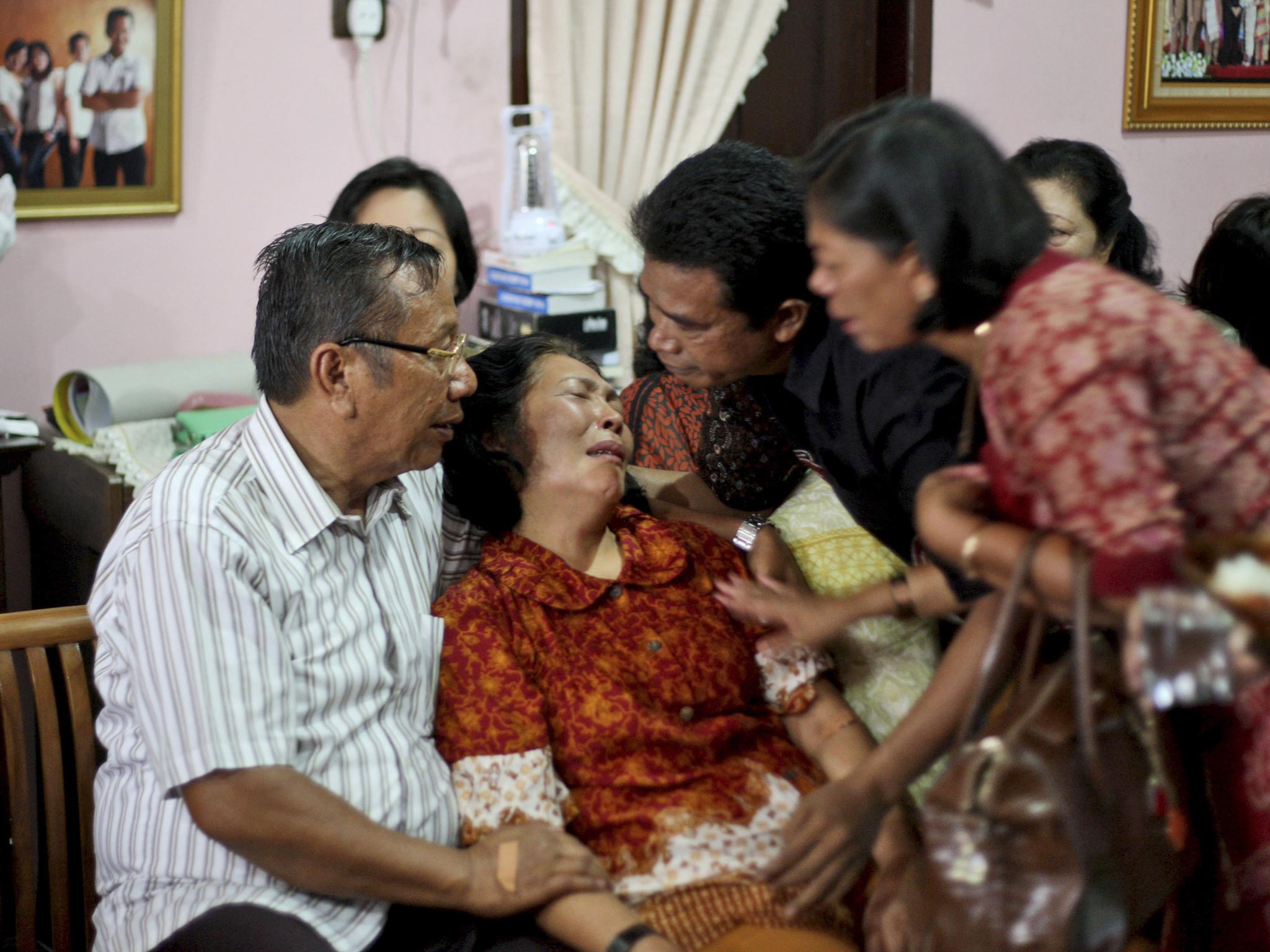 Family members comfort Chrisman Siregar (left) and his wife Herlina Panjaitan, the parents of Firman Siregar, one of the Indonesian citizens thought to have boarded the Malaysia Airlines jetliner