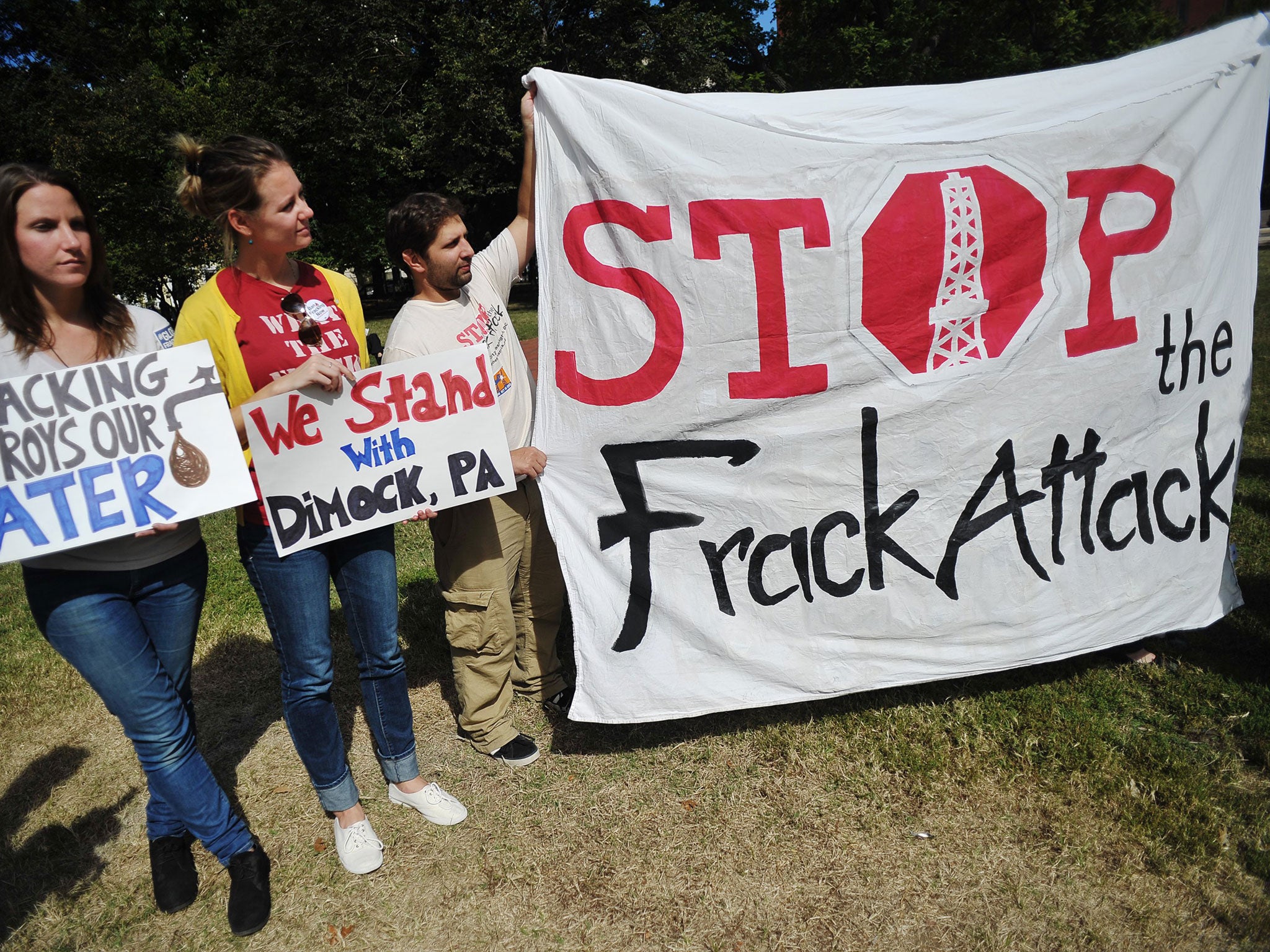 Opponents of hydraulic fracturing or 'fracking' hold placards during a rally in Lafayette Square, across from the White House in DC