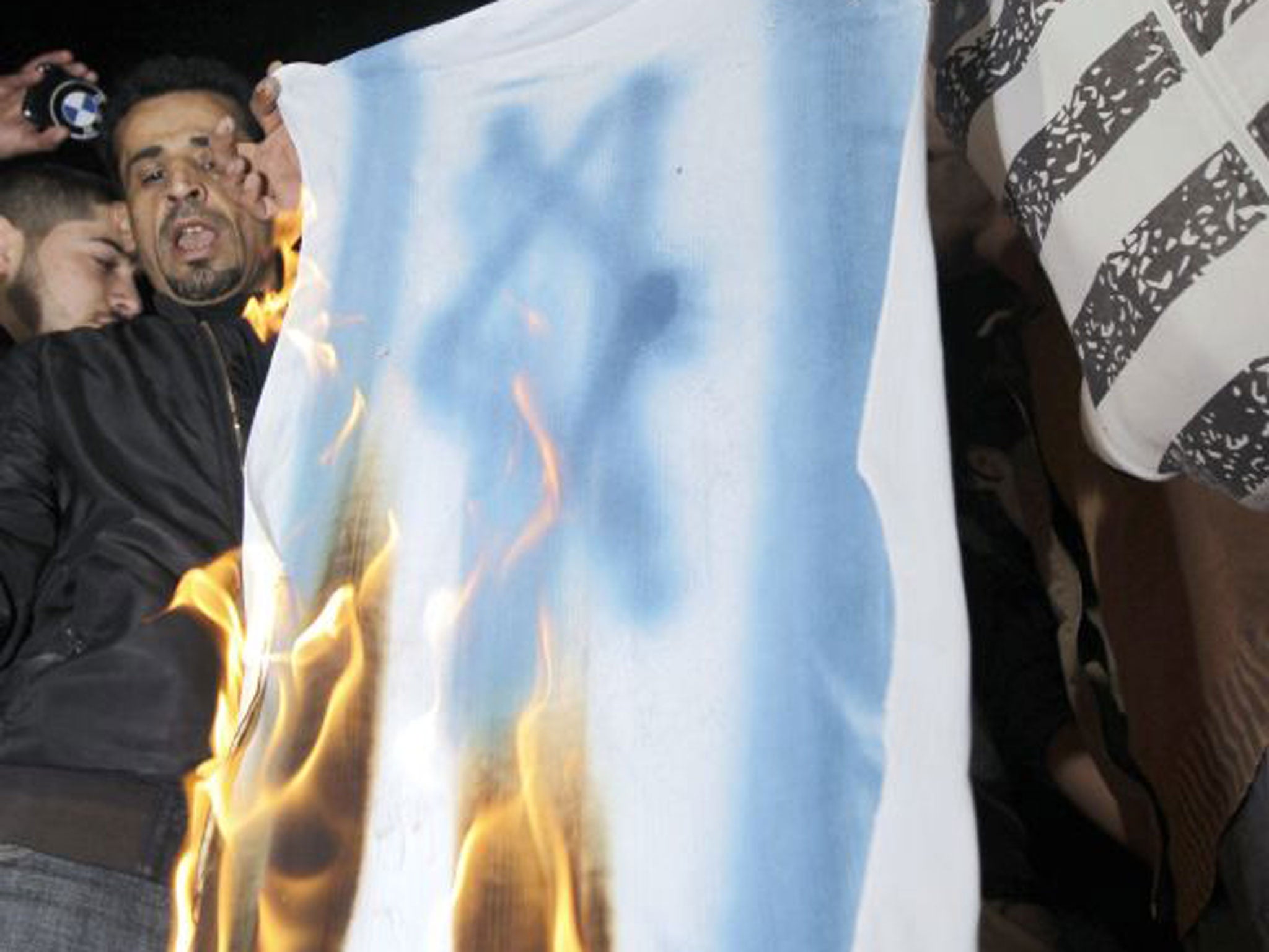 A copy of the Israeli flag is burned during a protest following the shooting of Palestinian-Jordanian judge Raed Alaa el-Deen Zaeiter