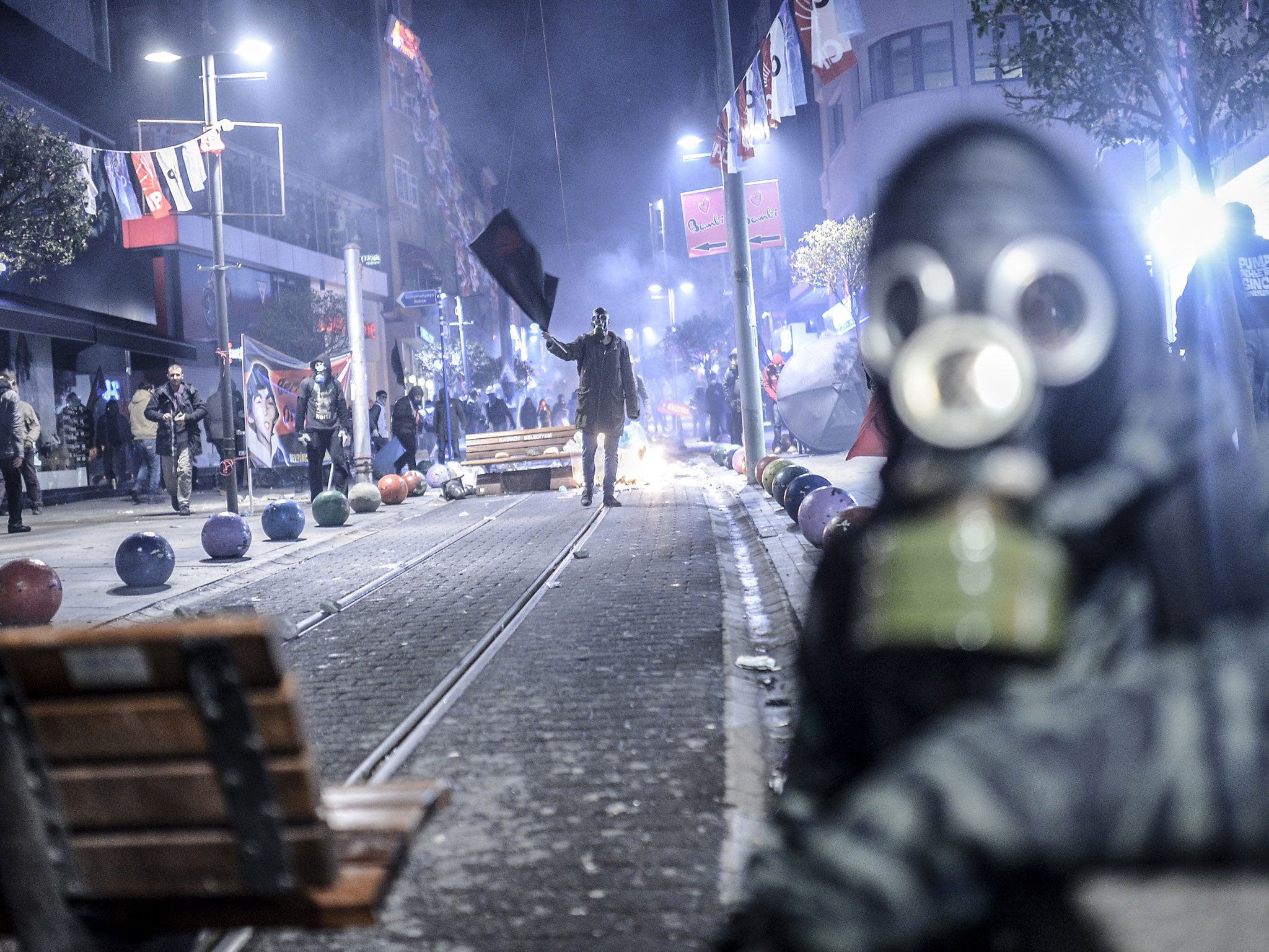 A protester waves a black flag during clashes with riot police in Kadikoy, on the Anatolian side of Istanbul, on March 11, 2014.