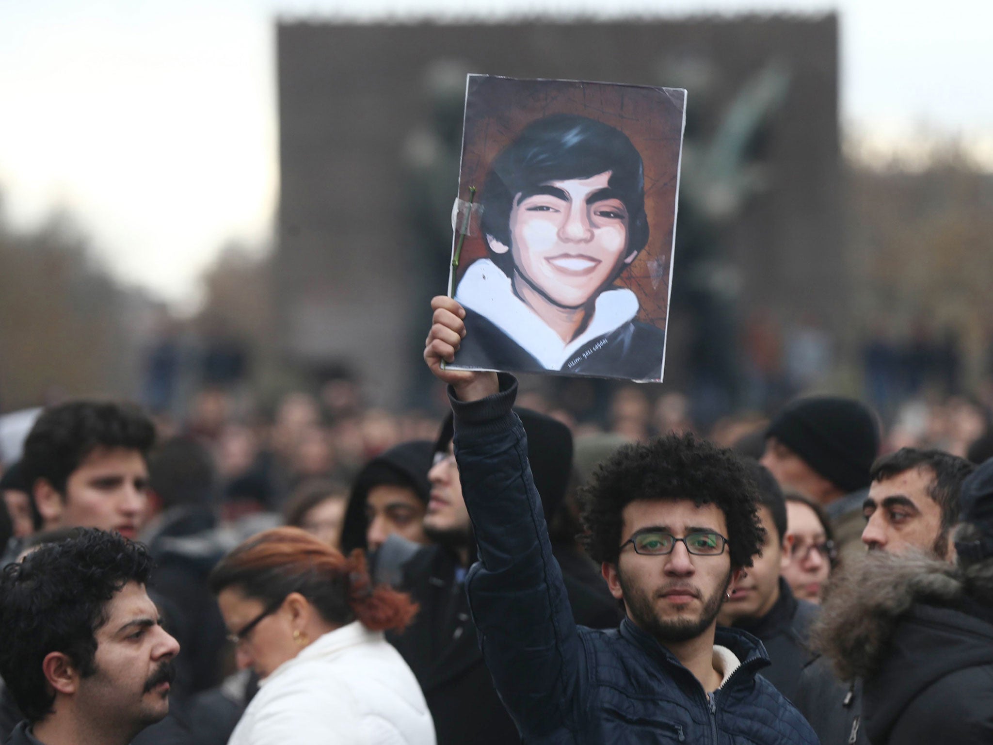 A protestor holds a placard displaying a portrait of Berkin Elvan after the announcement of the death of the teenager on 11 March 2014, in Ankara.