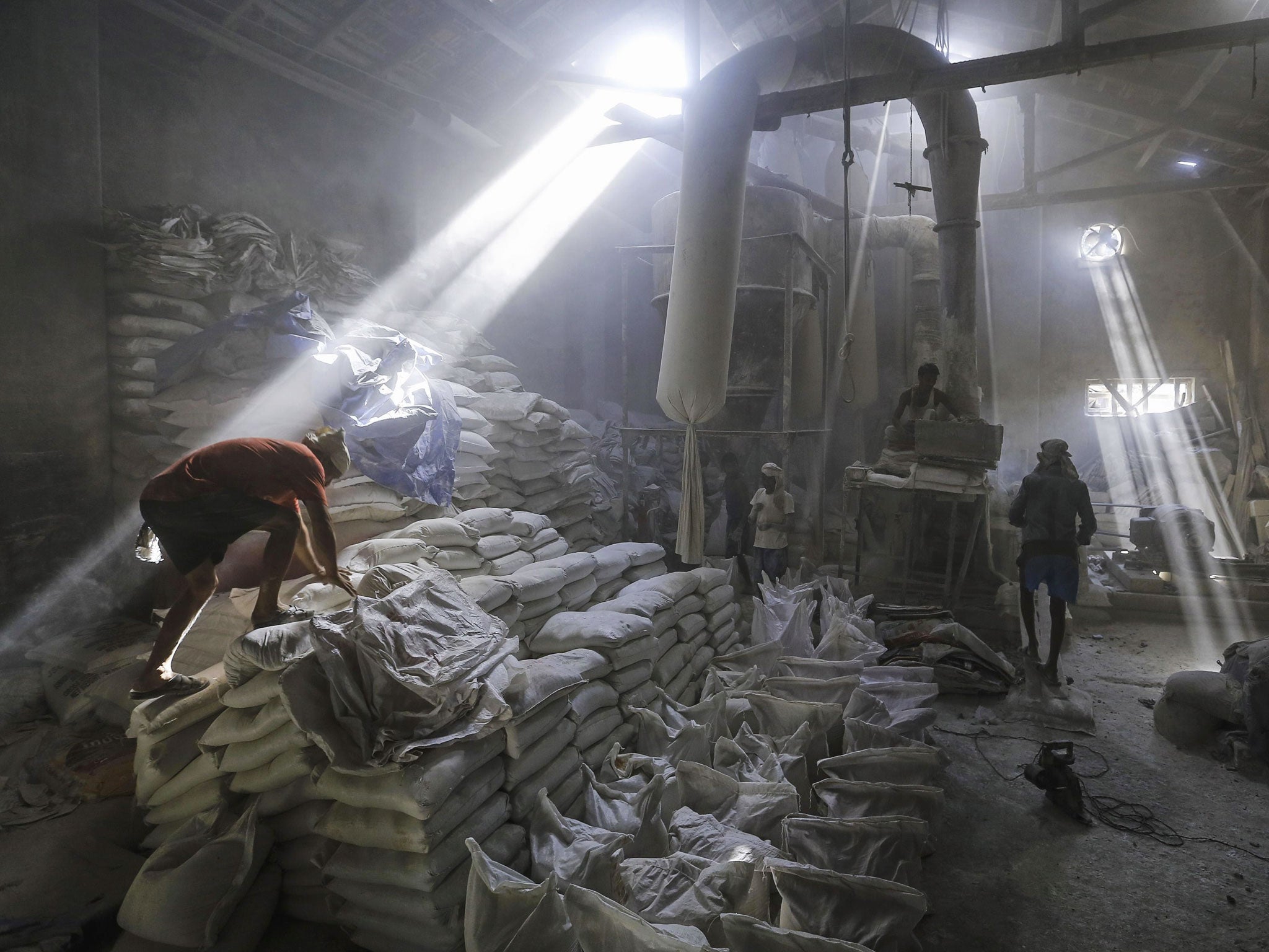 Employees work inside a limestone powder factory in an industrial area in Mumbai