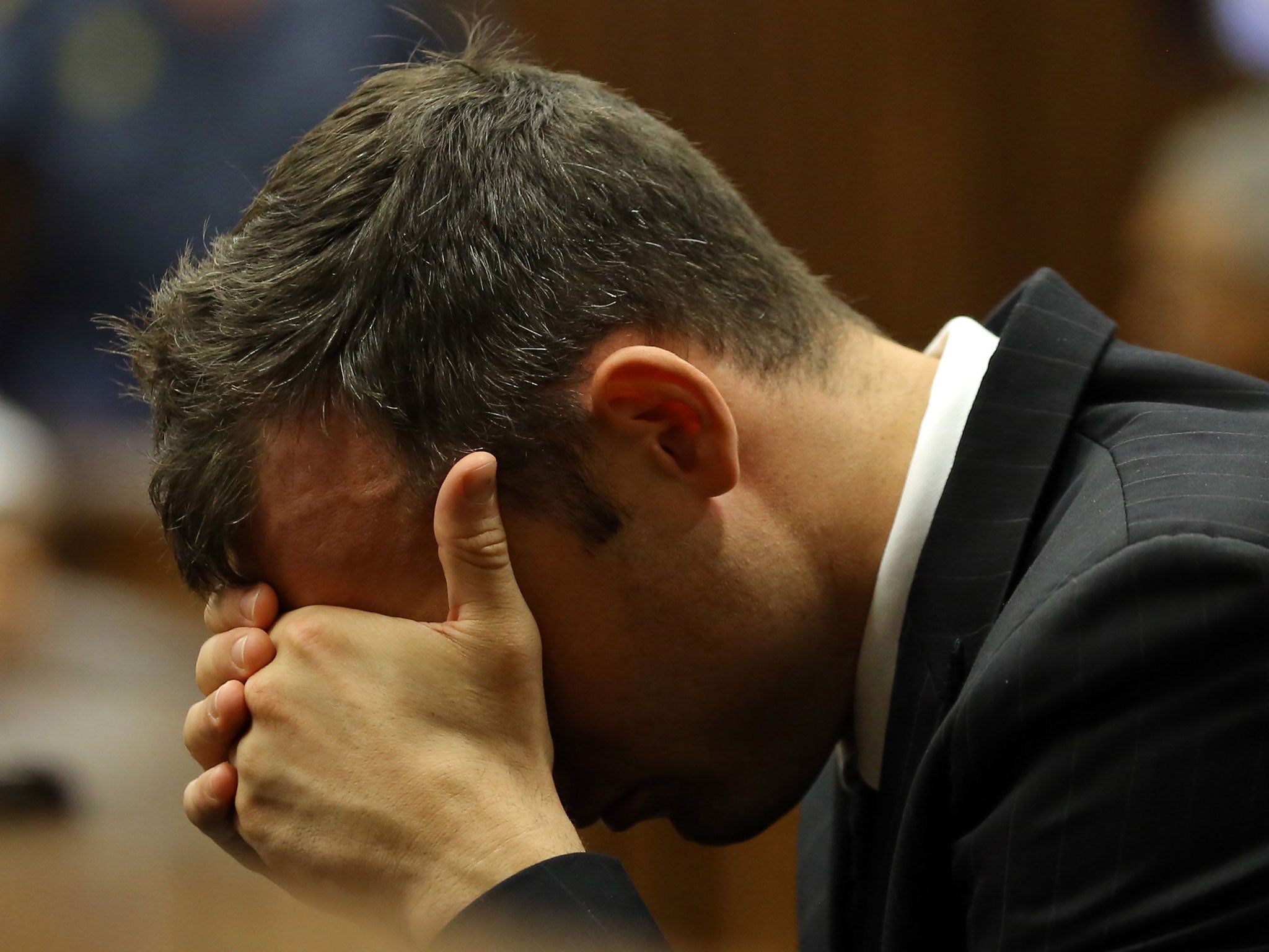 Oscar Pistorius places his head in his hands as he listens to the cross examination during his trial in court in Pretoria