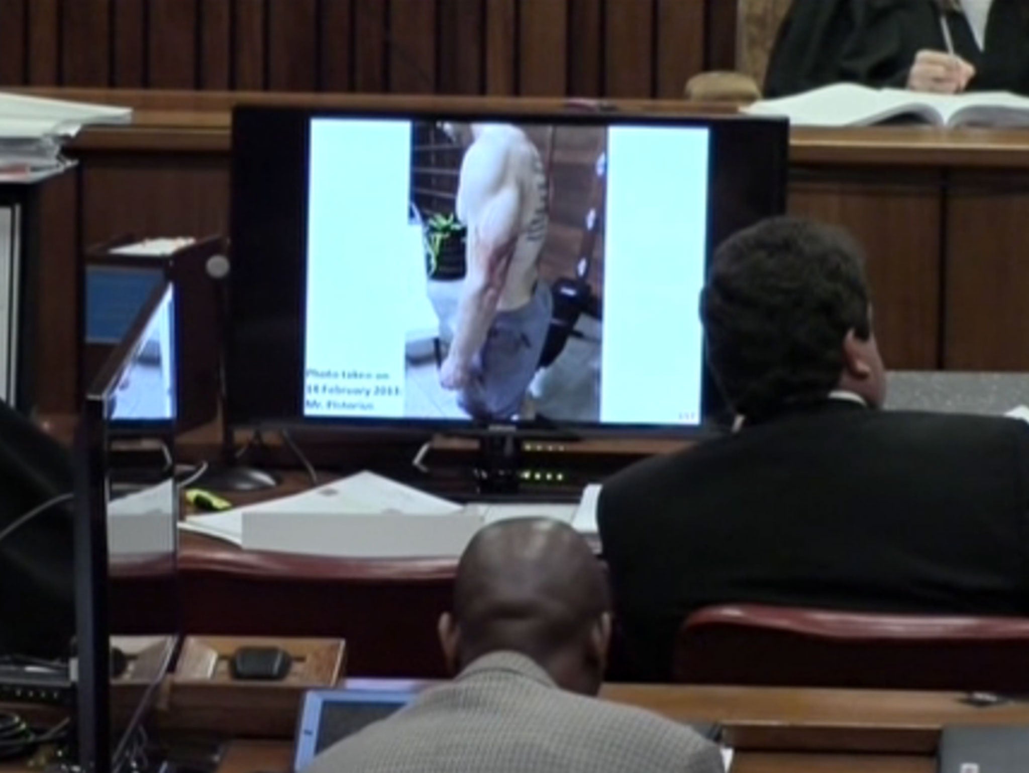 Pistorius from the waist up, with a tattoo visible on his back, and blood on his left arm