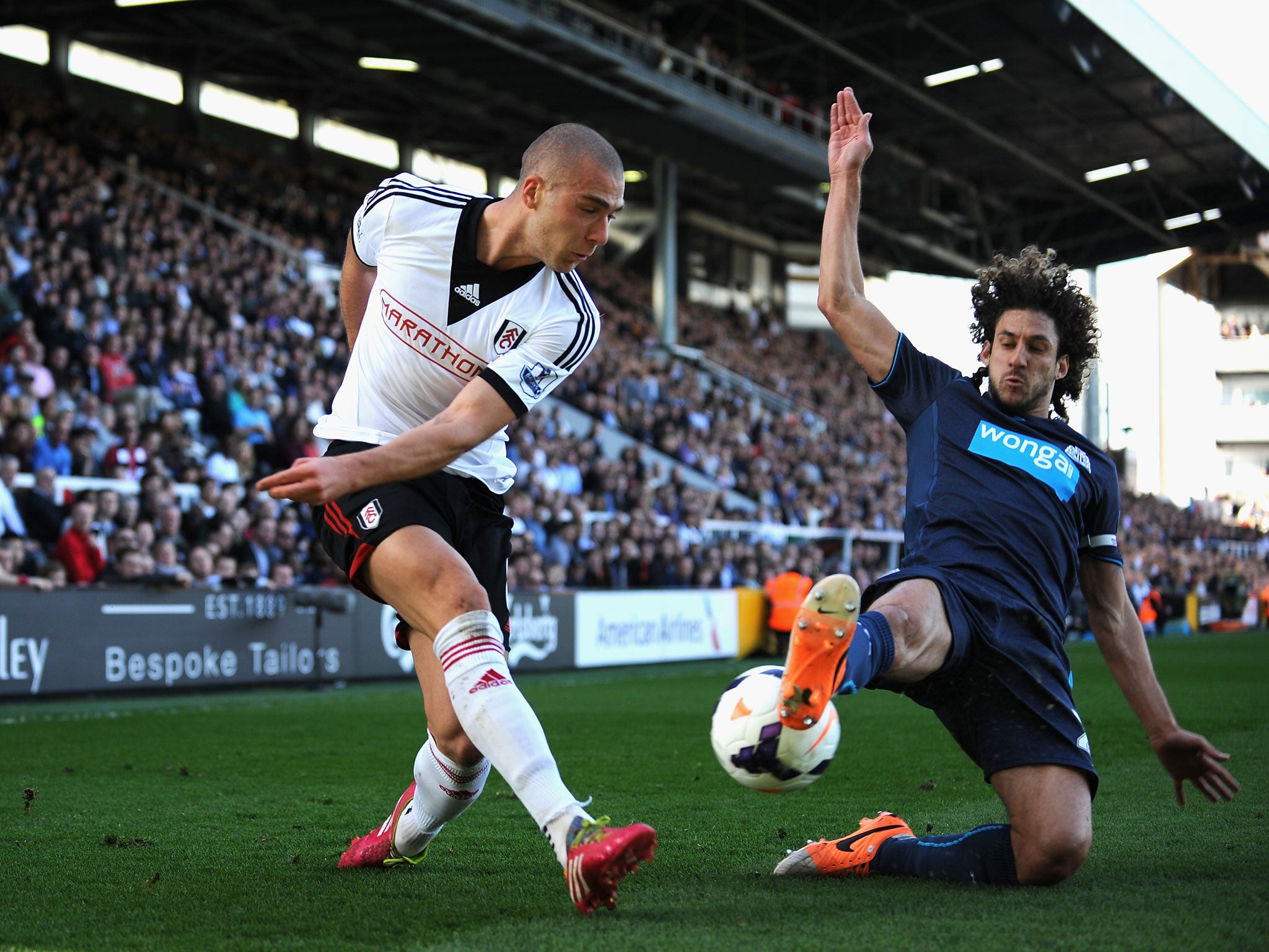 Pajtim Kasami of Fulham tackled by Fabricio Coloccini of Newcastle United