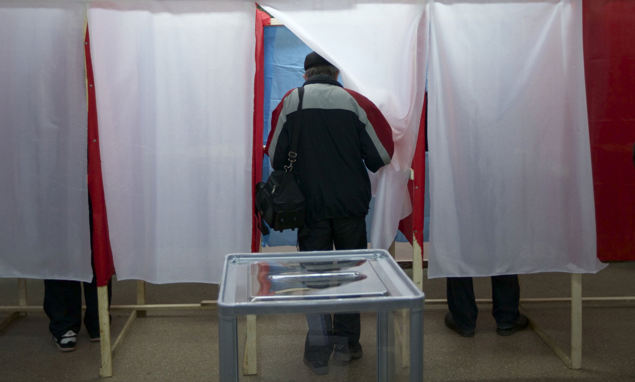 A man enters a booth to complete a ballot at a polling station in Simferopol, Ukraine