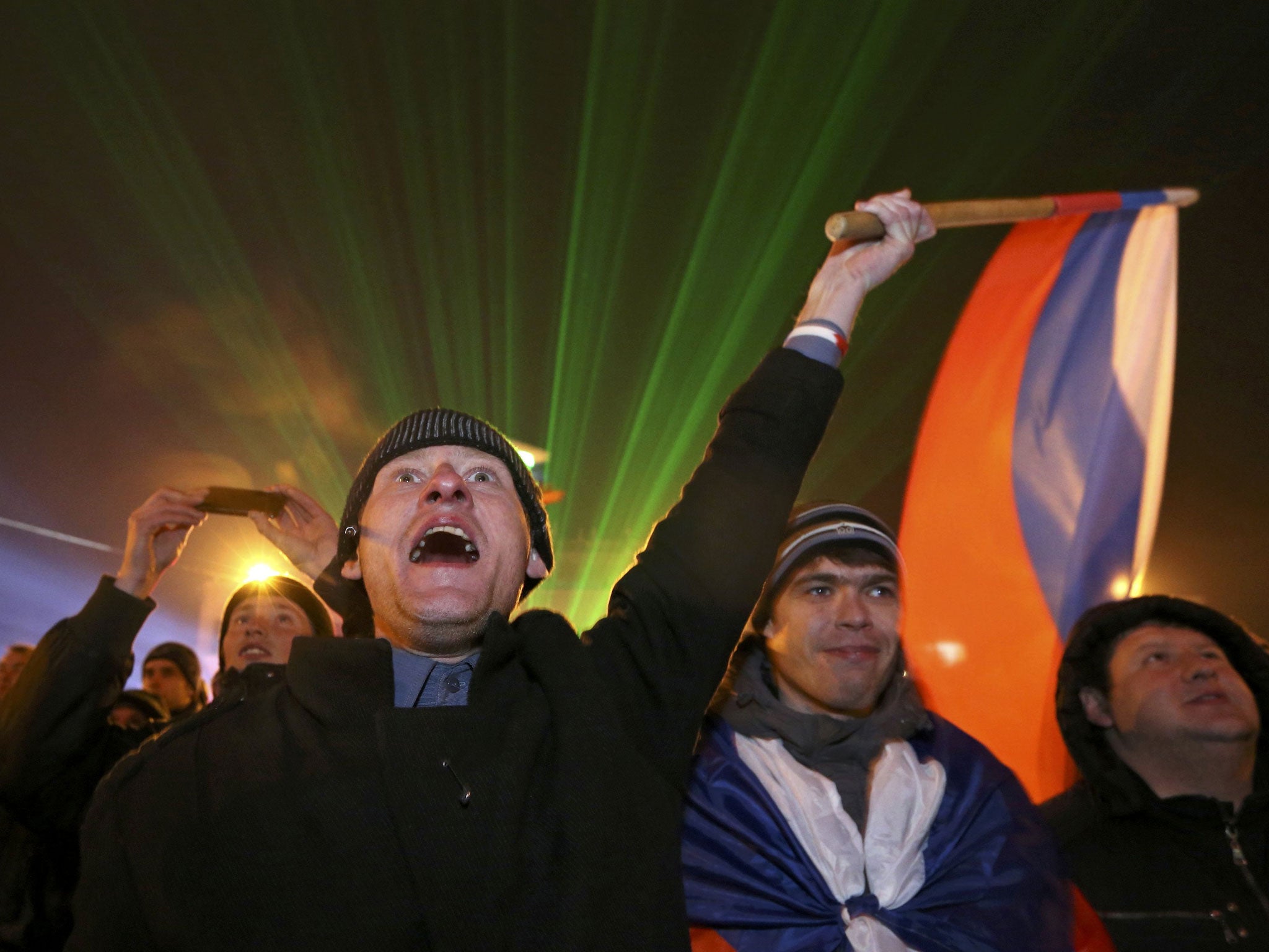 A man waves the Russian flag as the preliminary results of today's referendum are announced on Lenin Square in the Crimean capital of Simferopol