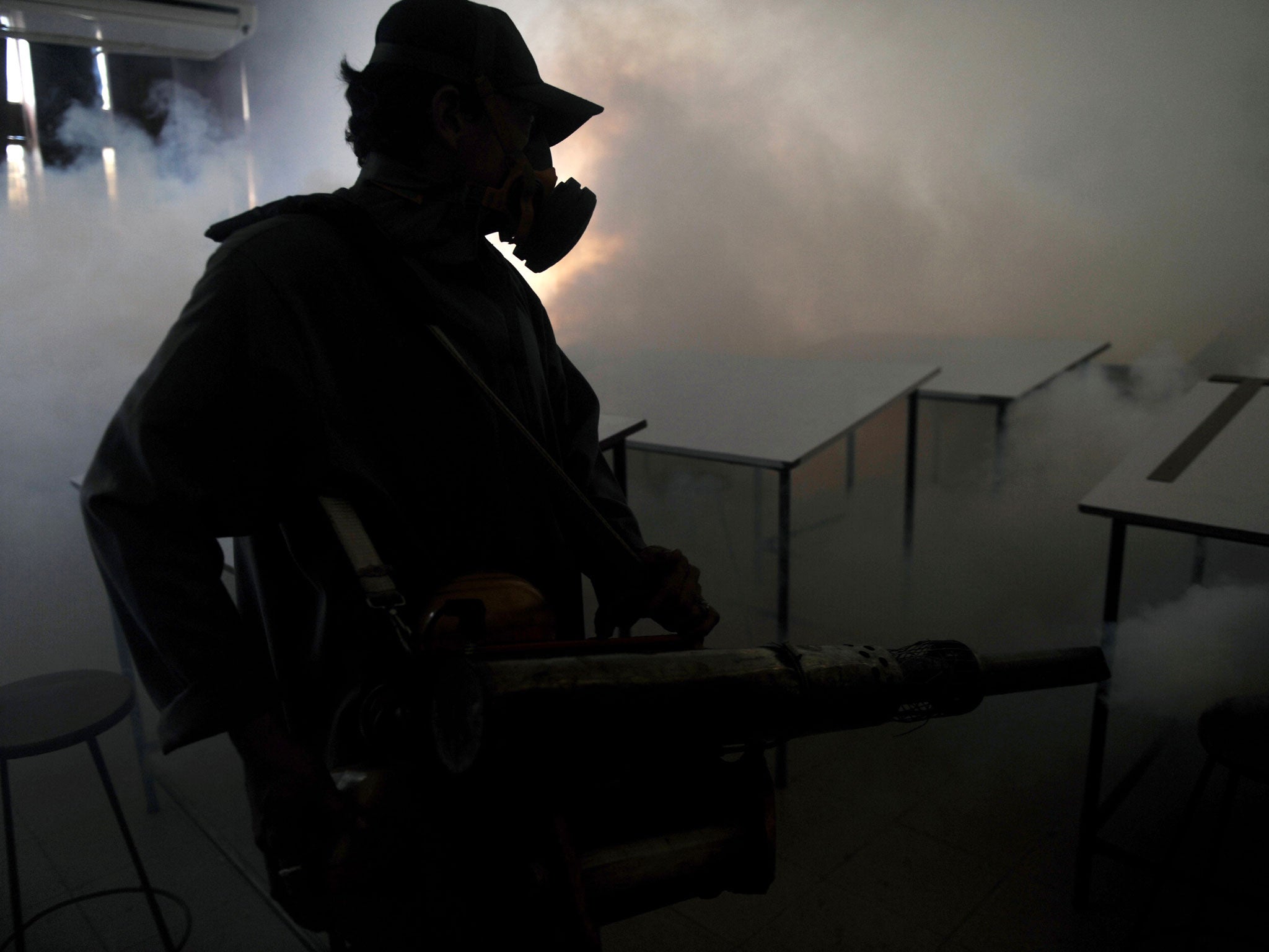 A Ministry of Health worker fumigates a public university which has suffered a dangerous outbreak of dengue fever