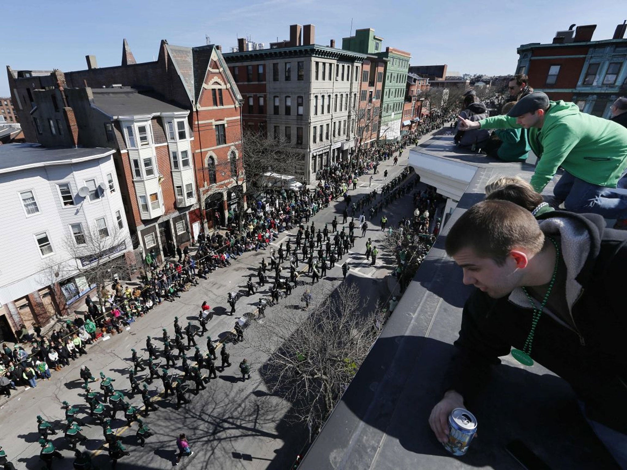 People watch the annual St. Patrick's Day parade from a roof in the South Boston neighborhood of Boston.