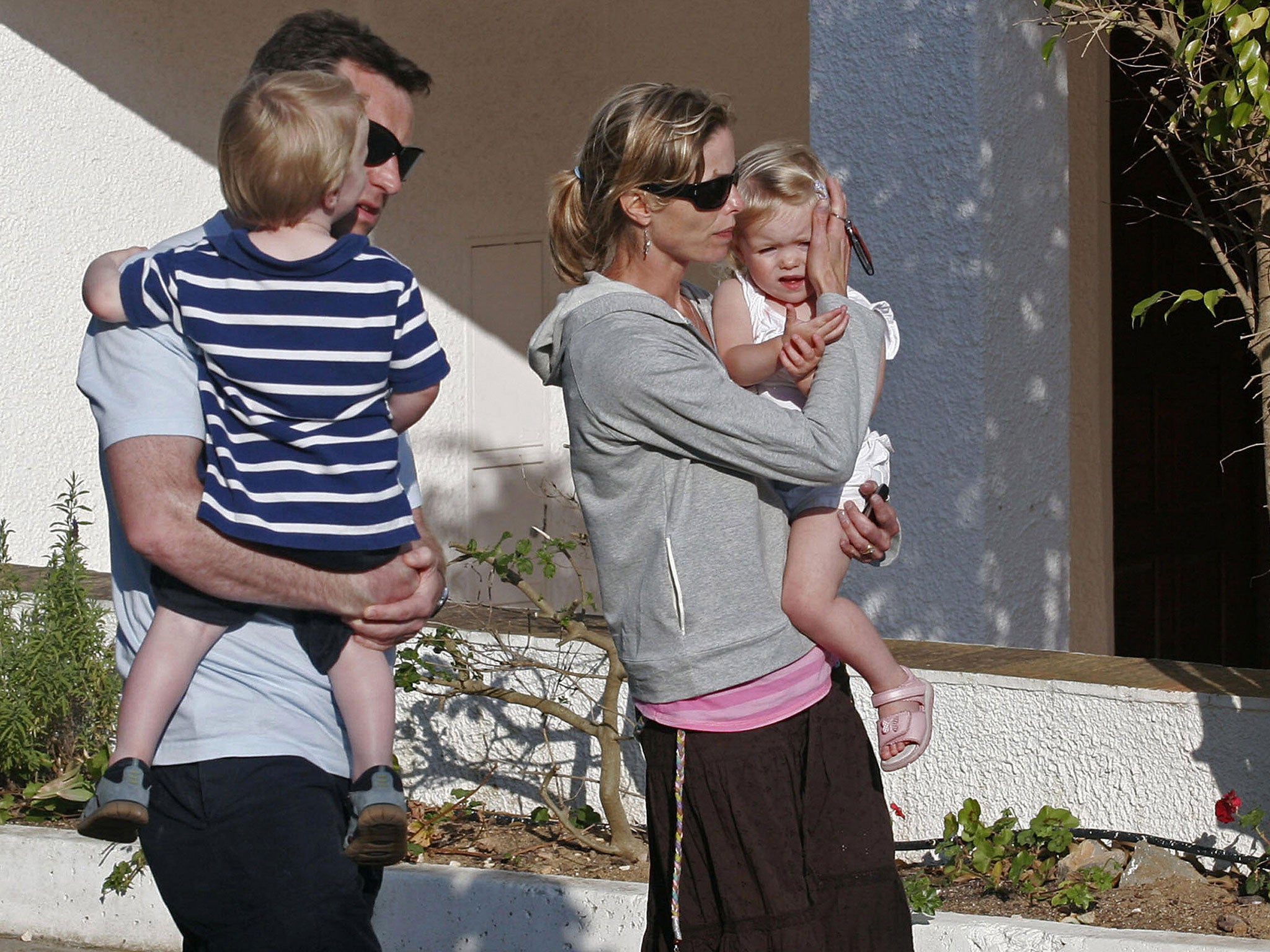 Gerald McCann and Kate McCann walk holding their two other children outside the Ocean club apartment hotel in Praia de Luz in May 2007