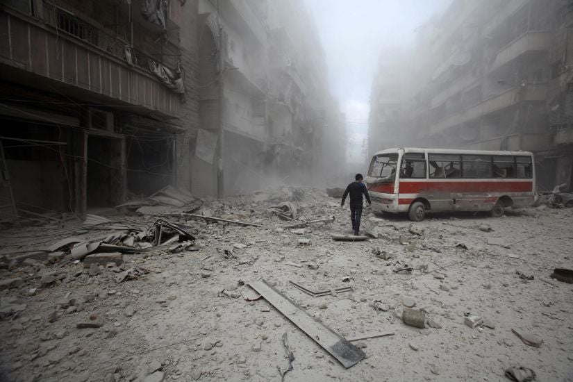A man inspects the damage at a site activists claim was hit by barrel bombs