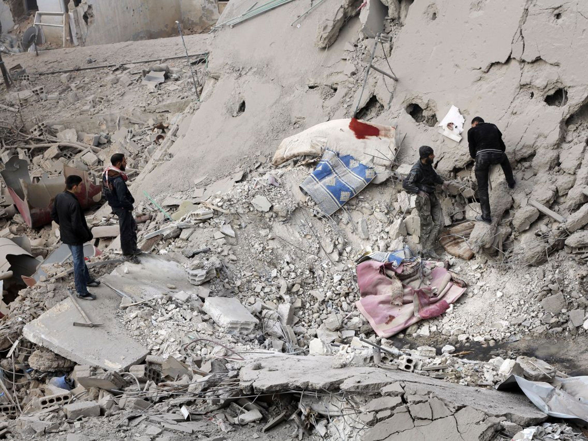 Syrians look through rubble following a reported airstrike attack by governmenet forces on Daraya, southwest of the capital Damascus