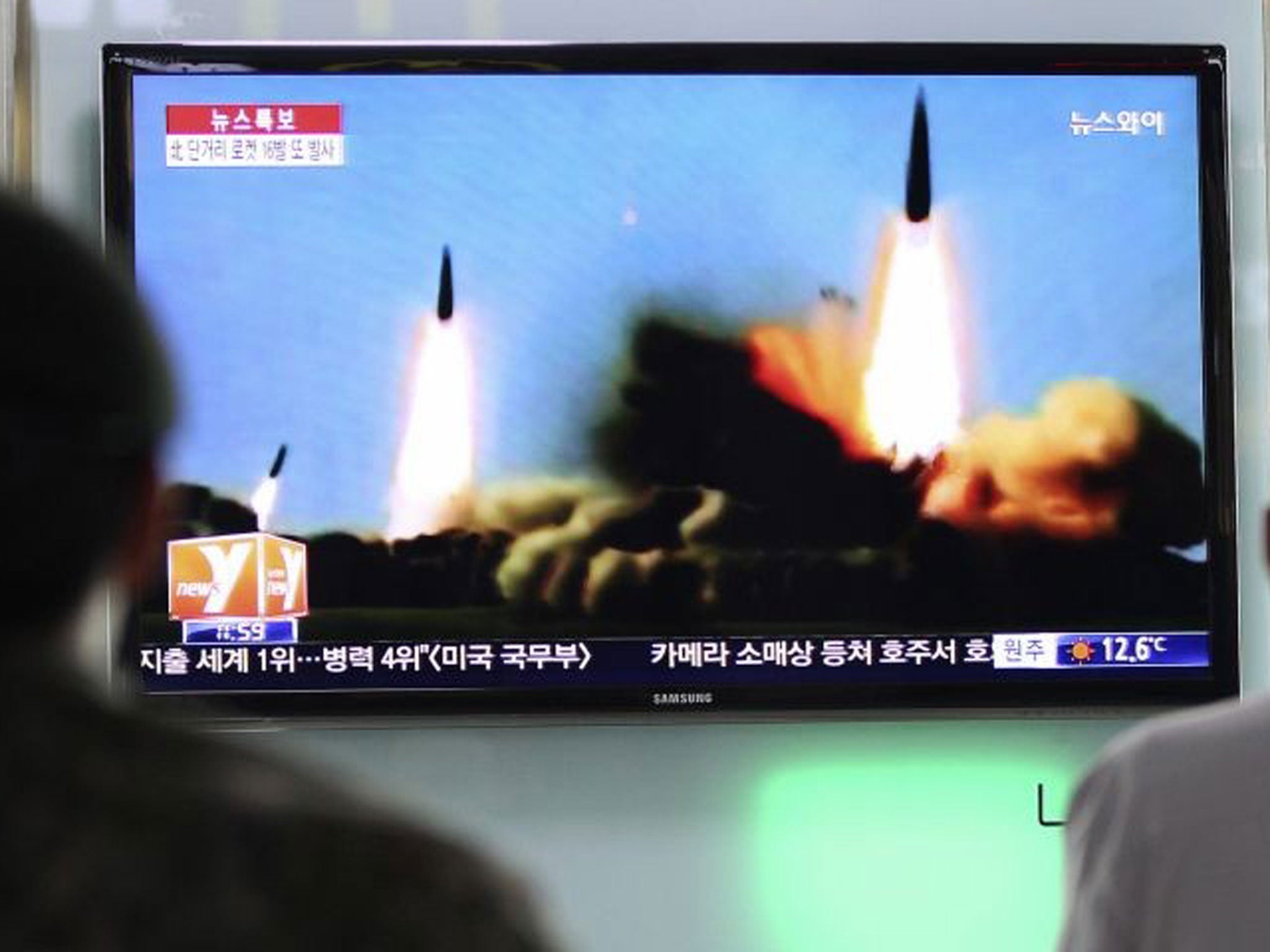 People in Seoul watch a news programme showing rockets previously launched by Pyongyang