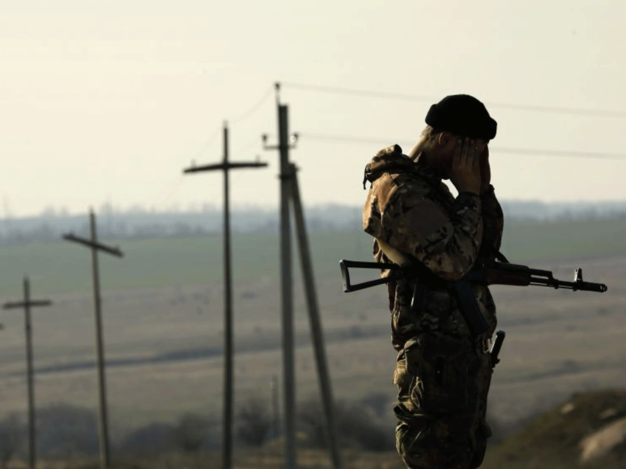 A Ukrainian soldier stands guard outside a Ukrainian Army military camp set up on a field close to the Russian border in east Ukraine