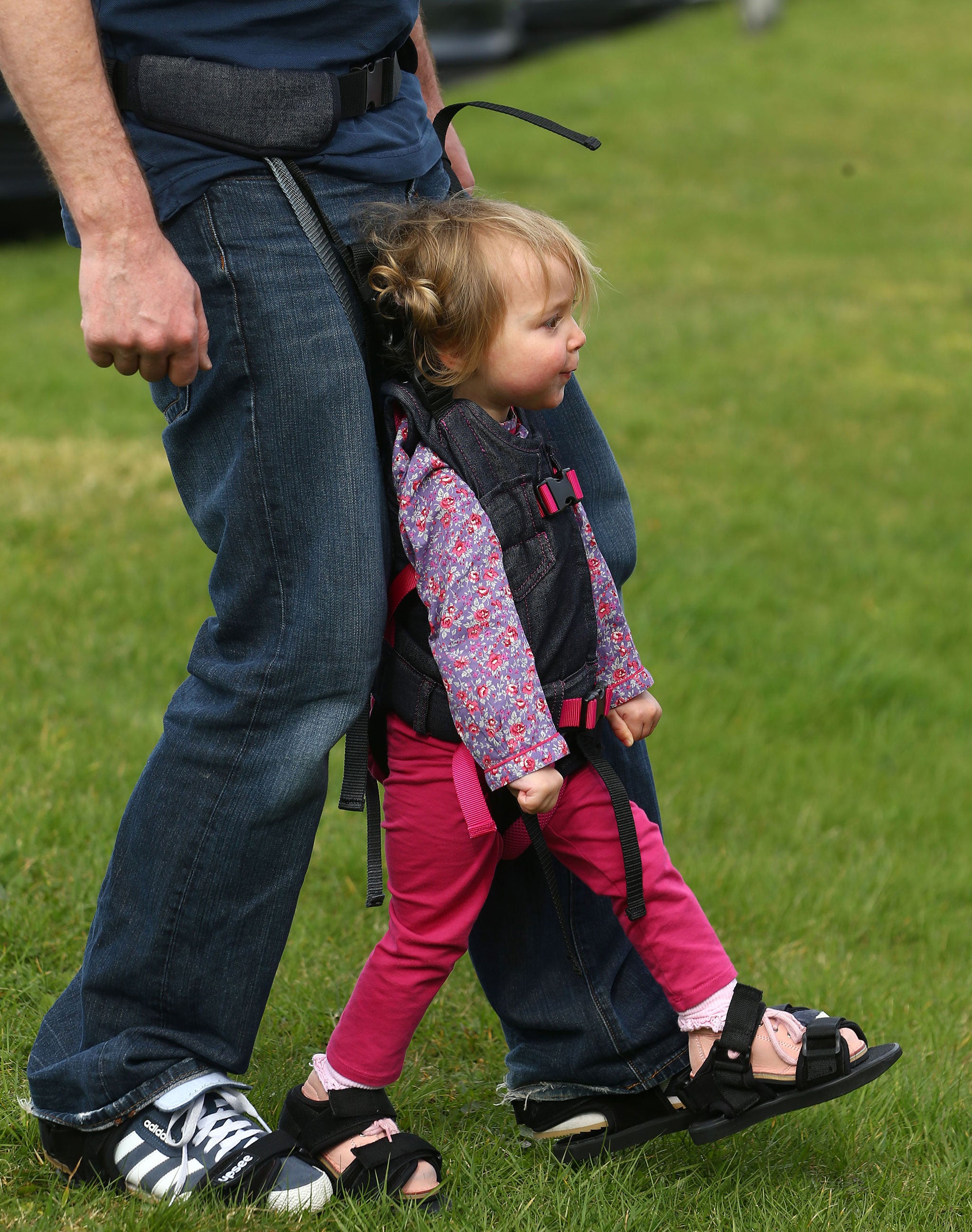 Charlotte Taylor, three, using a Firefly Upsee, a new standing and walking harness for children with motor impairment (PA)