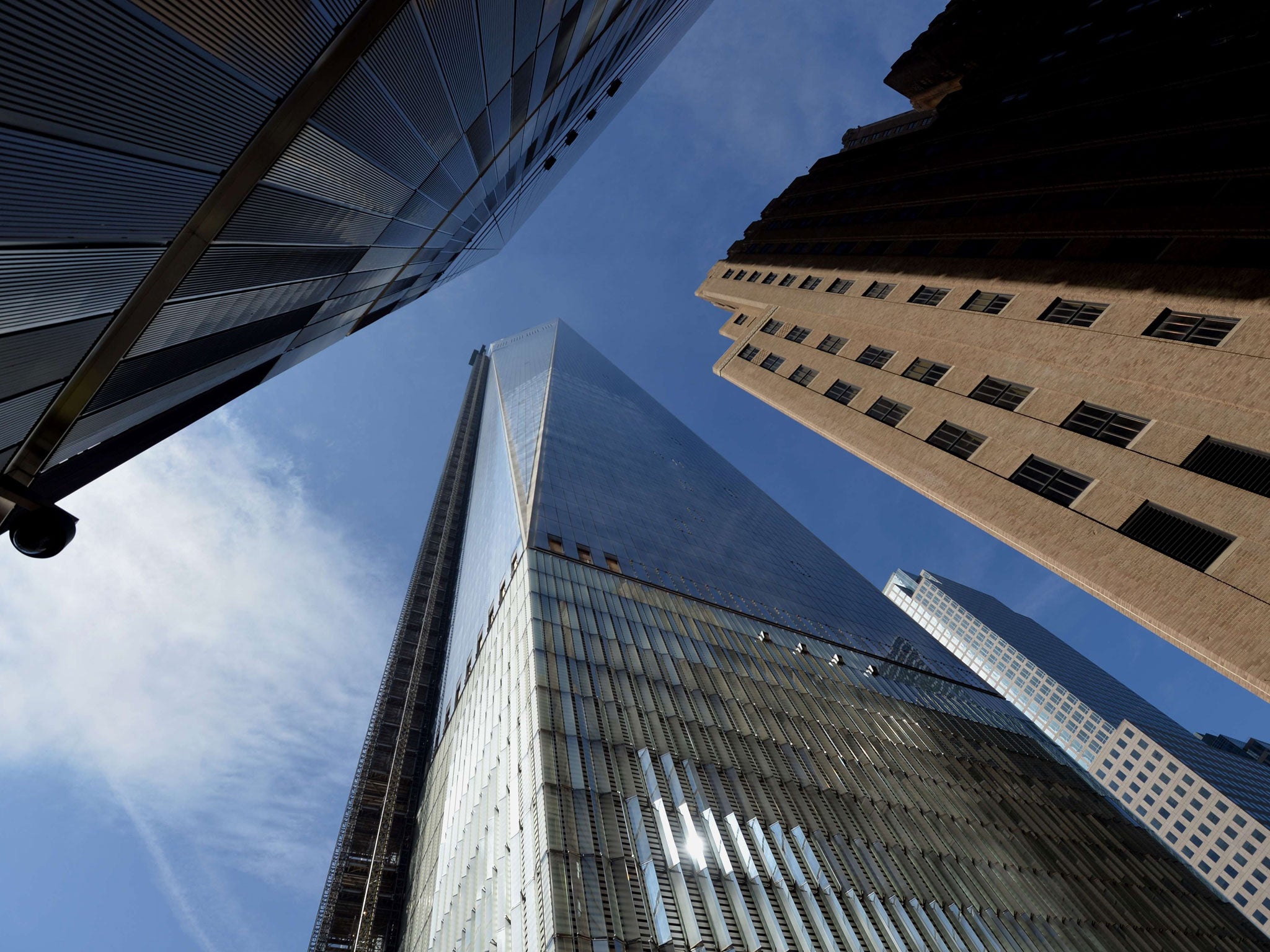 One World Trade Center is seen between nearby buildings in Lower Manhattan