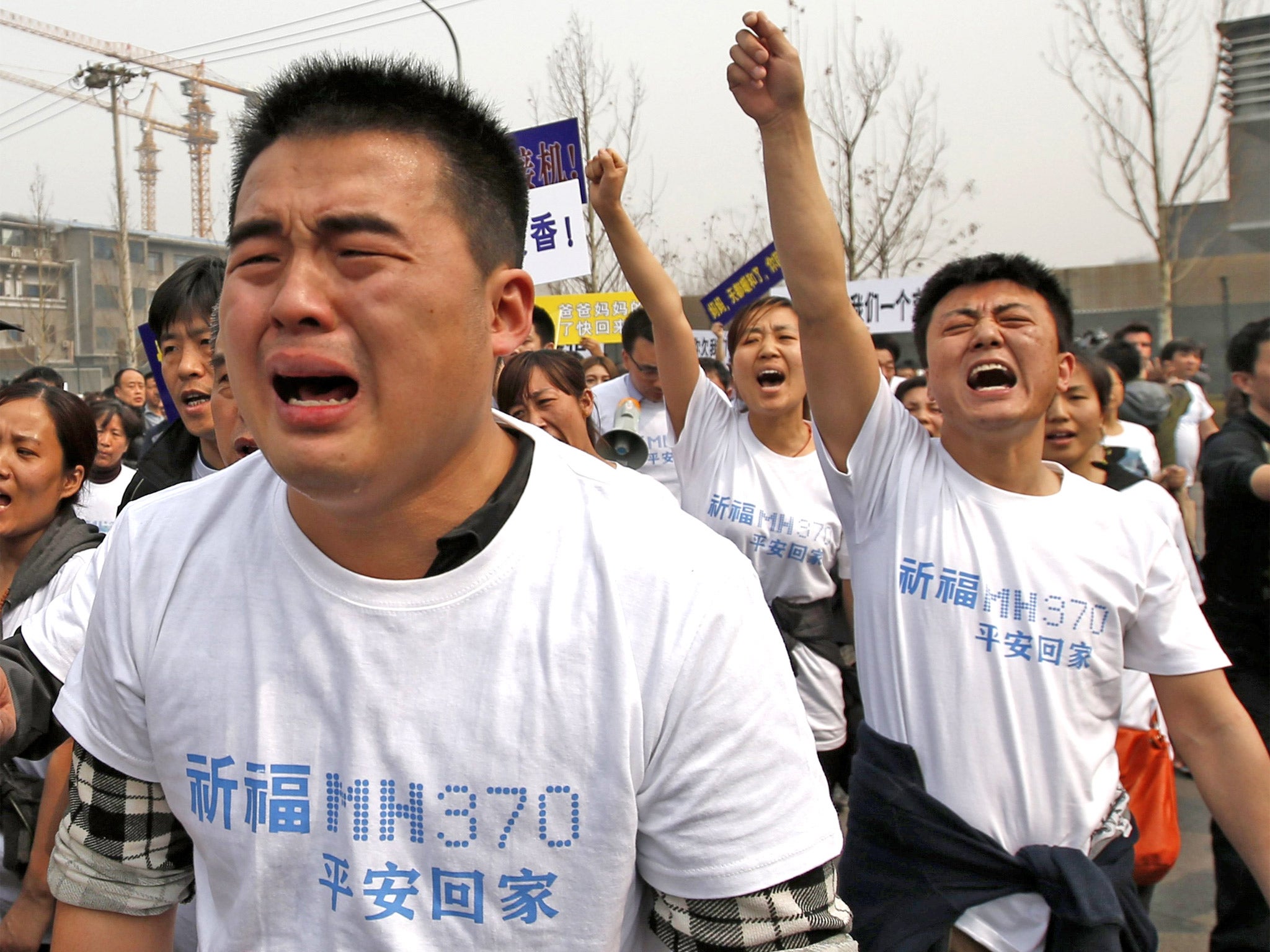 Family members of passengers and crew on the missing Malaysia Airlines jet outside the Malaysian embassy in Beijing, before trying to storm the building