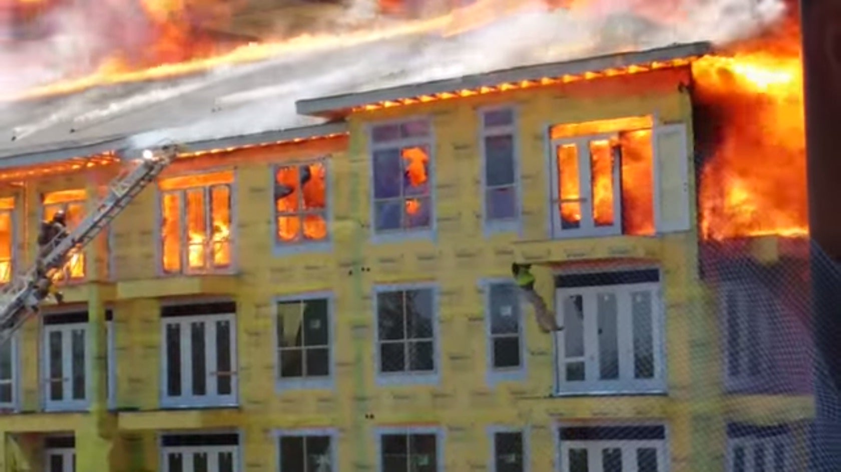 The man dangles from the apartment complex's top floor