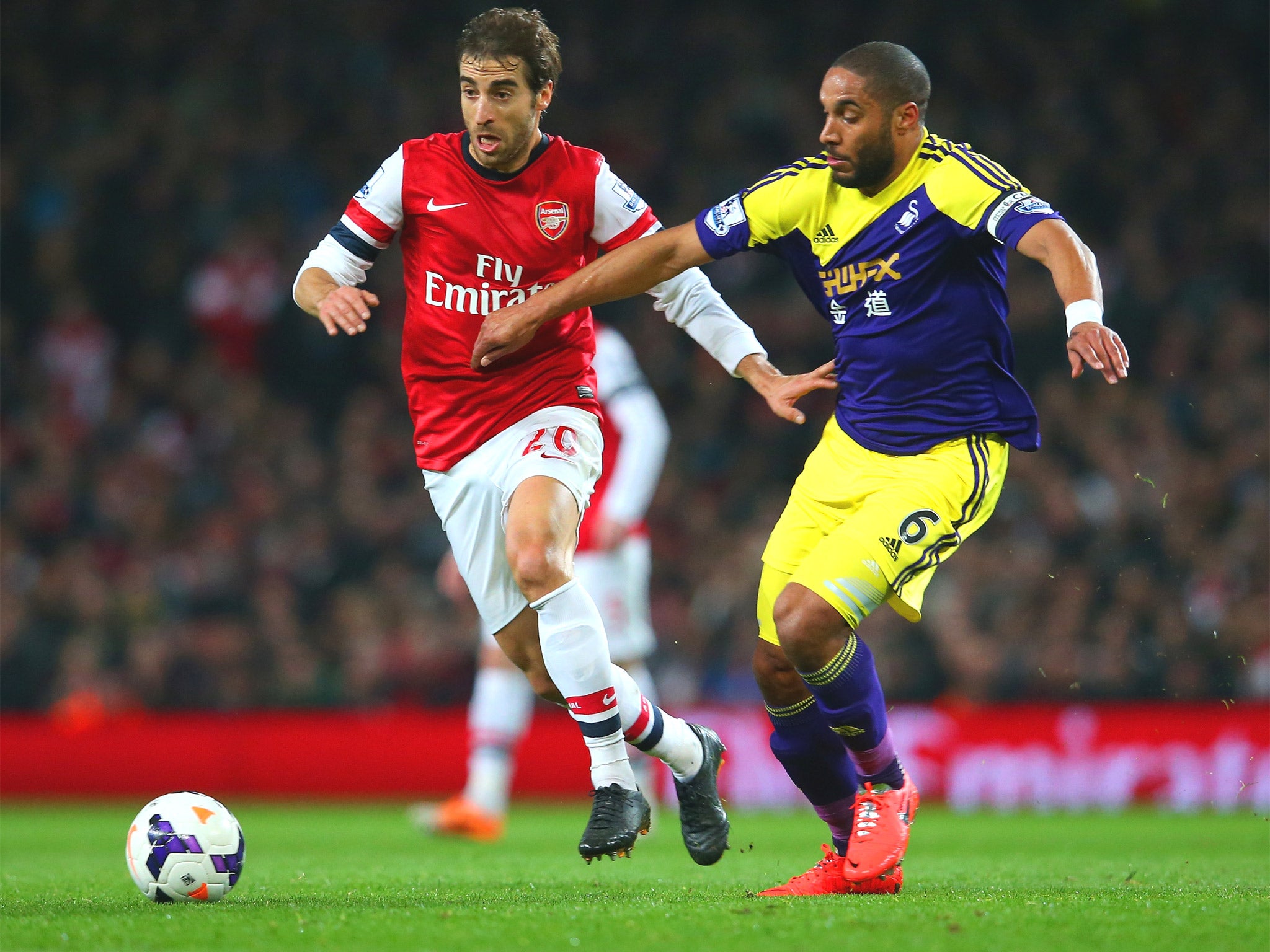 Mathieu Flamini (left) battles with Swansea’s Ashley Williams on Tuesday