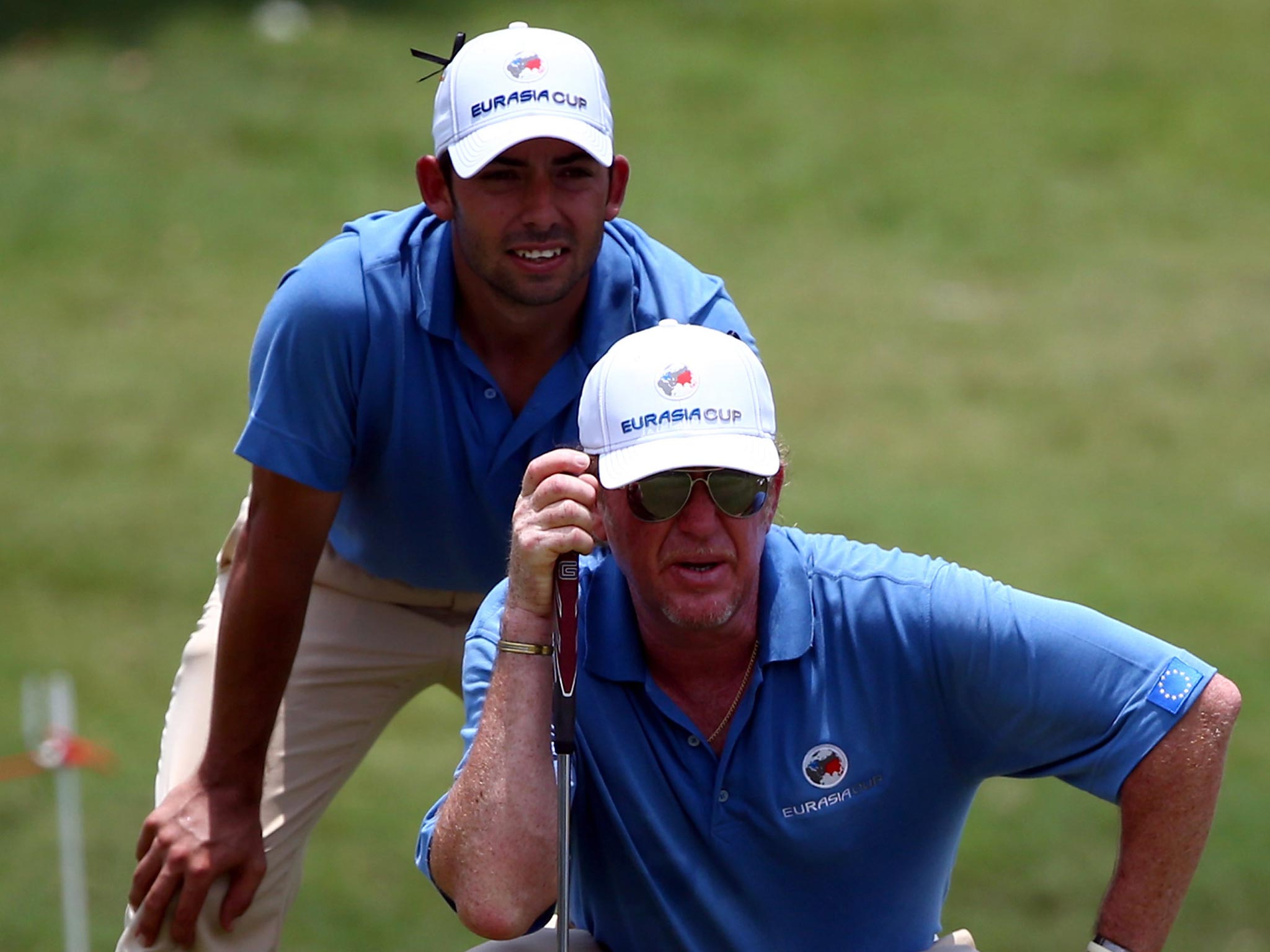 Pablo Larrazabal and Miguel Angel Jimenez of Team Europe lines up for a shot on the 16th hole during day one of the EurAsia Cup