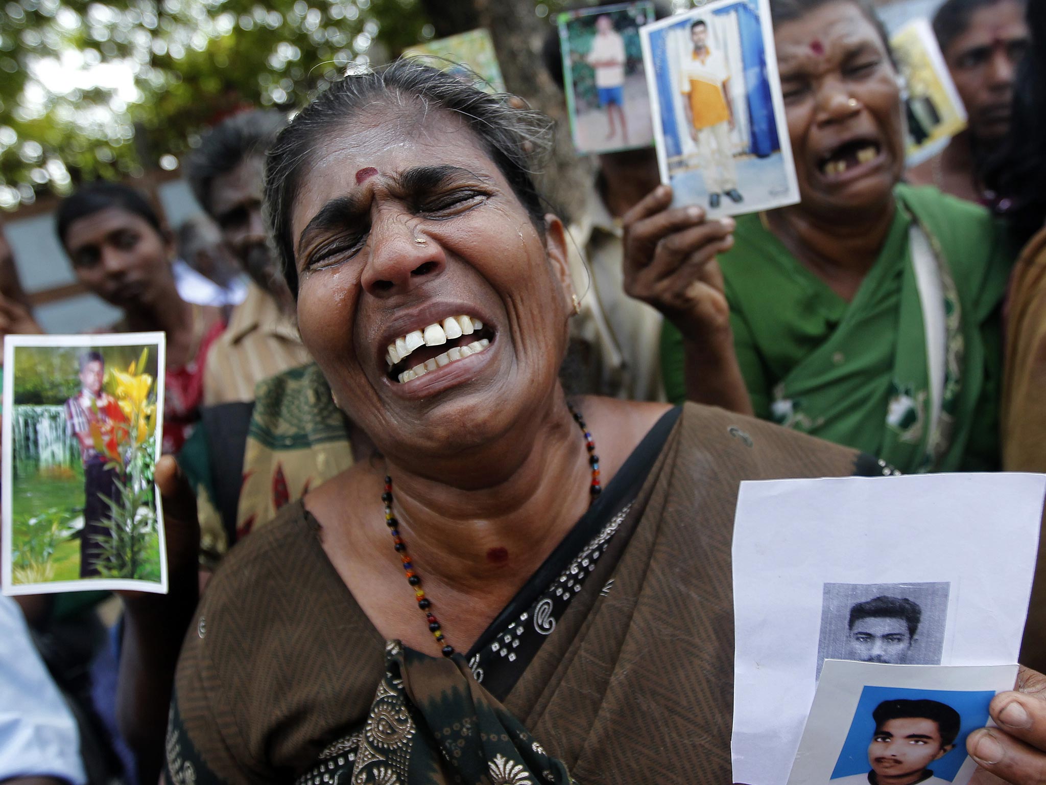 A Tamil woman cries as she holds up an image of her disappeared family member during the war against Liberation Tigers of Tamil Eelam (LTTE) at a protest in Jaffna