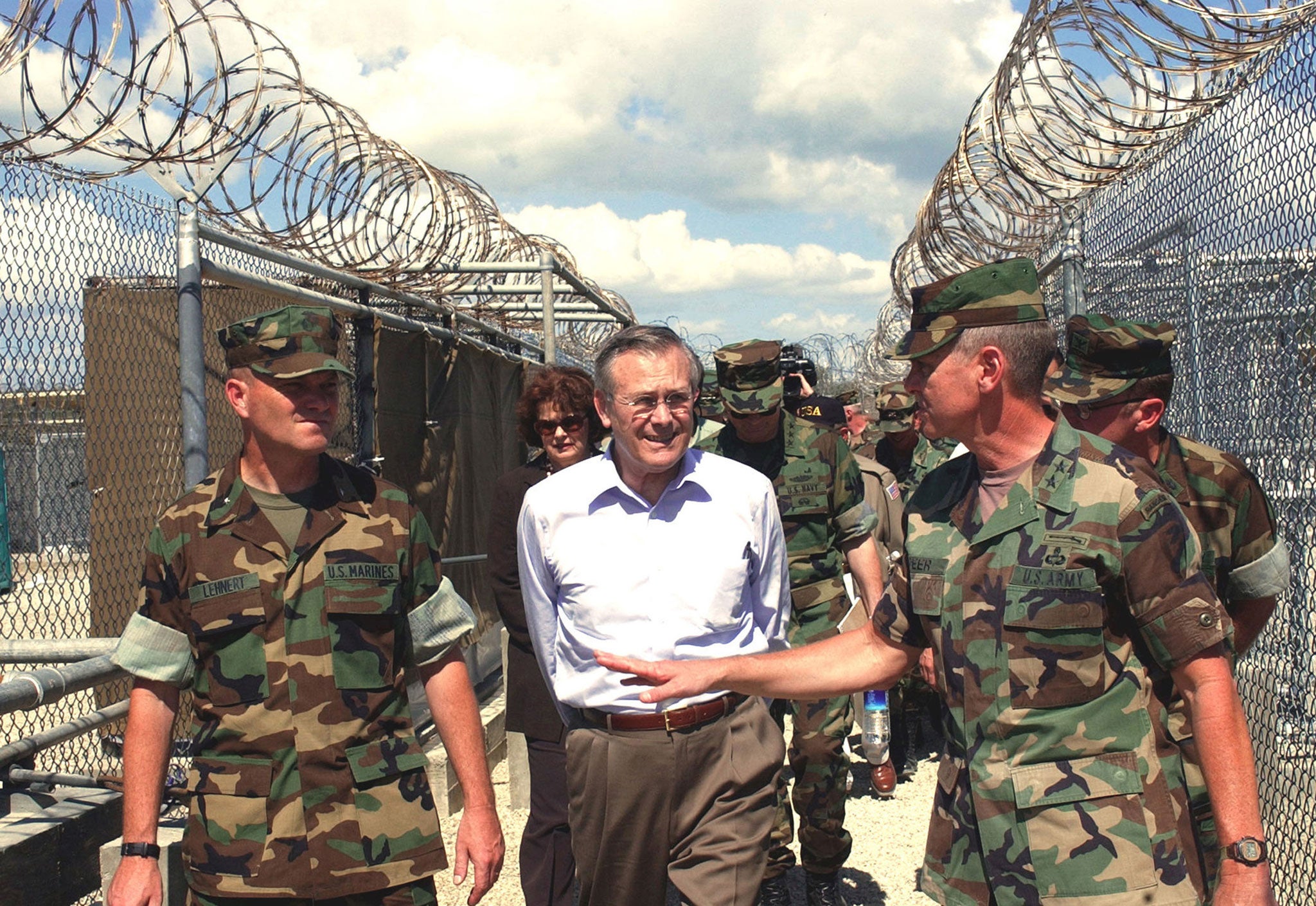 Courting controversy: Rumsfeld (centre) visits Camp X-Ray at U.S. Naval Base Guantanamo Bay, Cuba in 2002