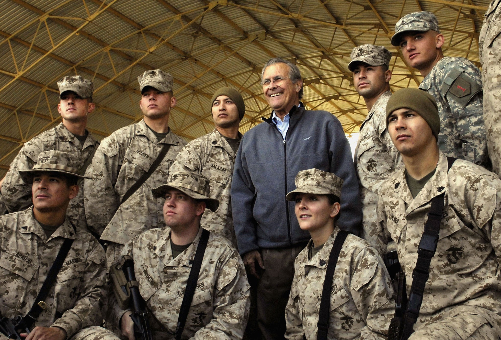 Stepping down: Rumsfeld poses with U.S. troops at the Al Asad Air Base in Iraq in 2006 (Getty Images)