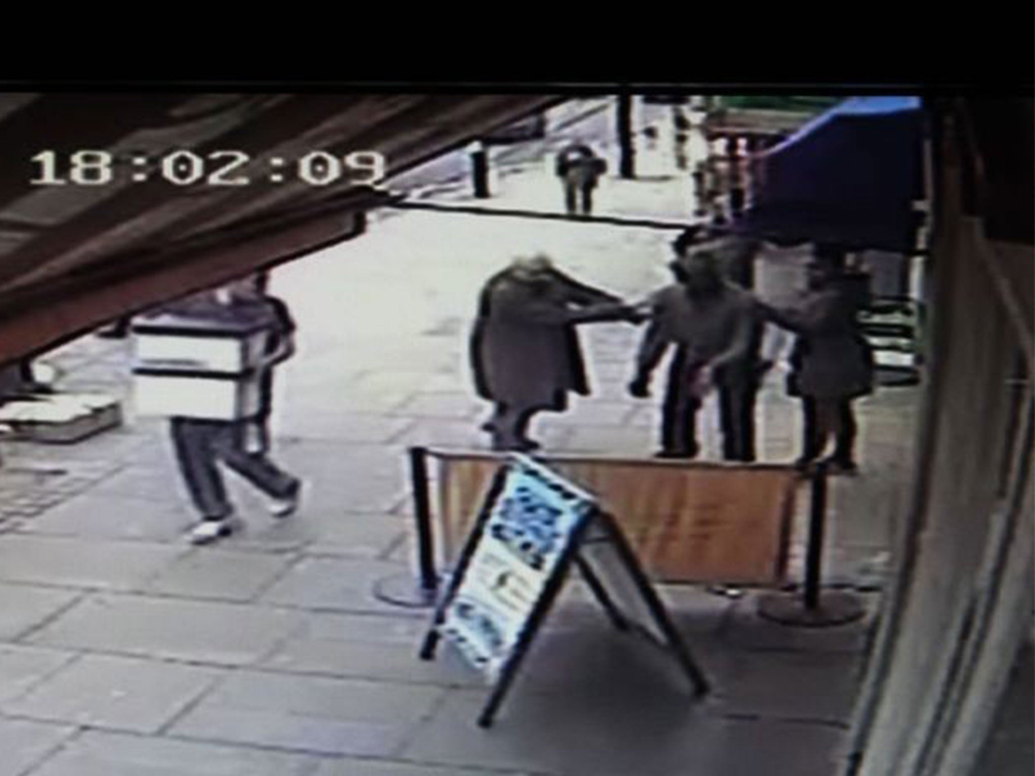 The injured man is comforted by bystanders after the axe attack in Islington