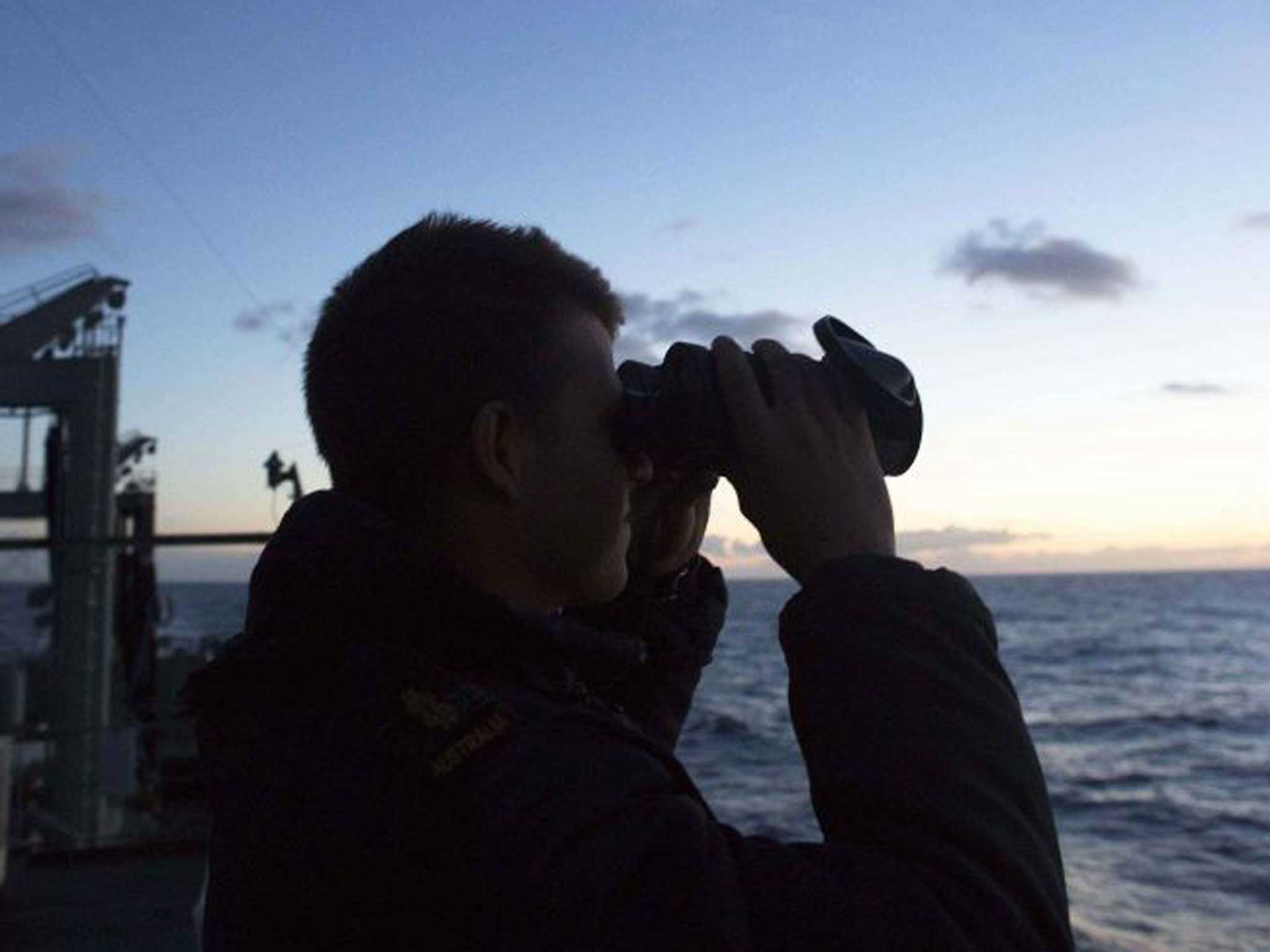 A Wing Commander of the Royal New Zealand Air Force scours the ocean from the flight deck