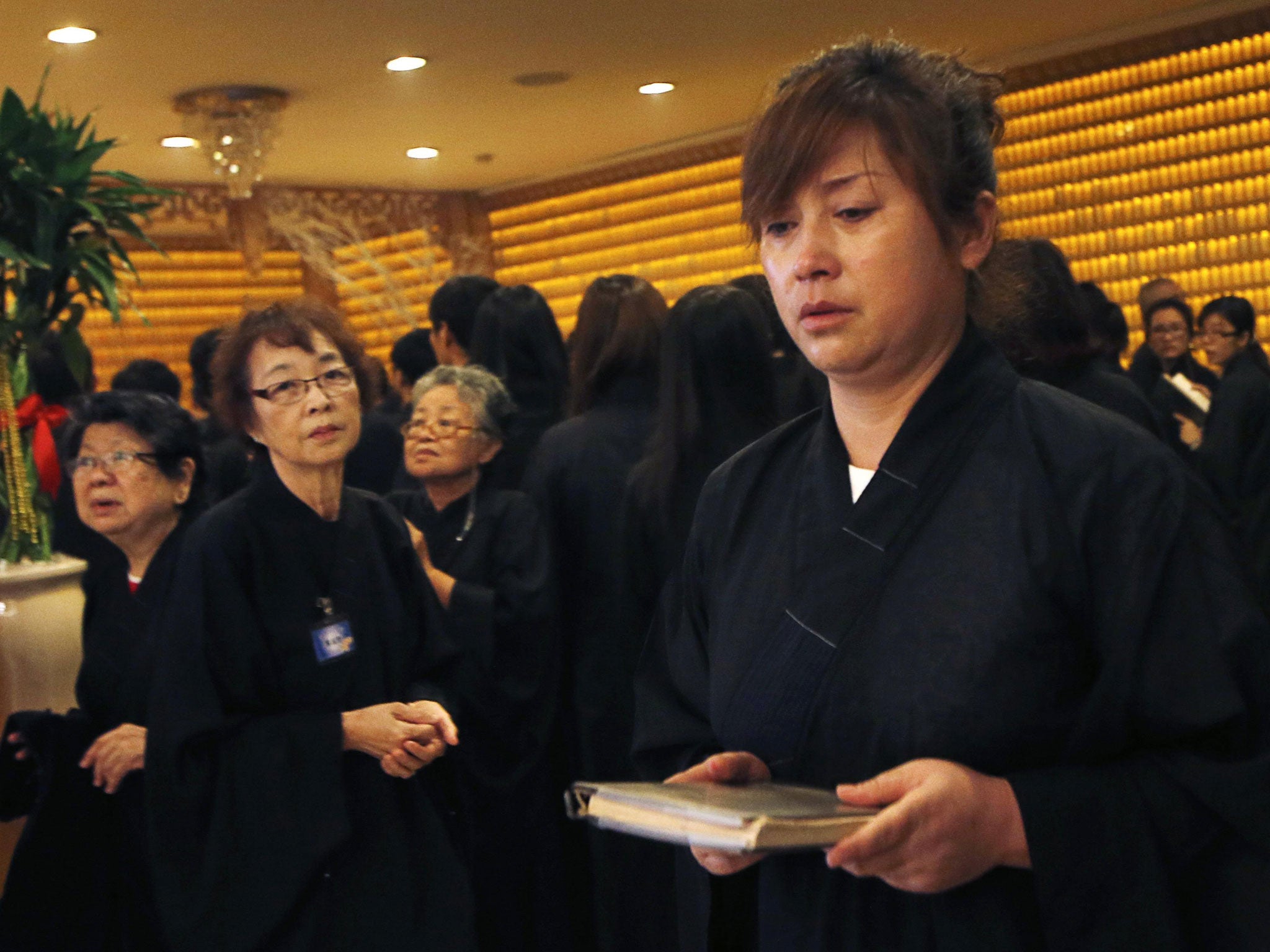 Chinese relatives of passengers onboard the missing Malaysia Airlines Flight MH370 prepare to recite prayers for her loved ones at Fo Guang Shan Buddhist temple in Petaling Jaya