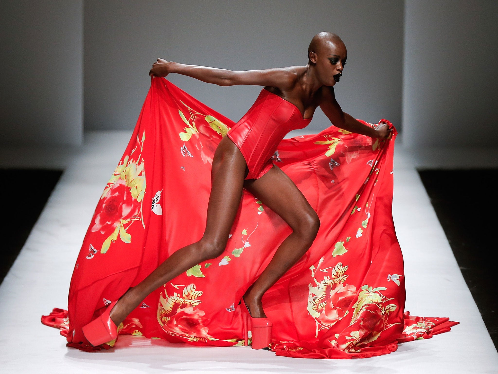 A model falls over on the runway at SECCRY Hu Sheguang Collection 2014 show during Mercedes-Benz China Fashion Week