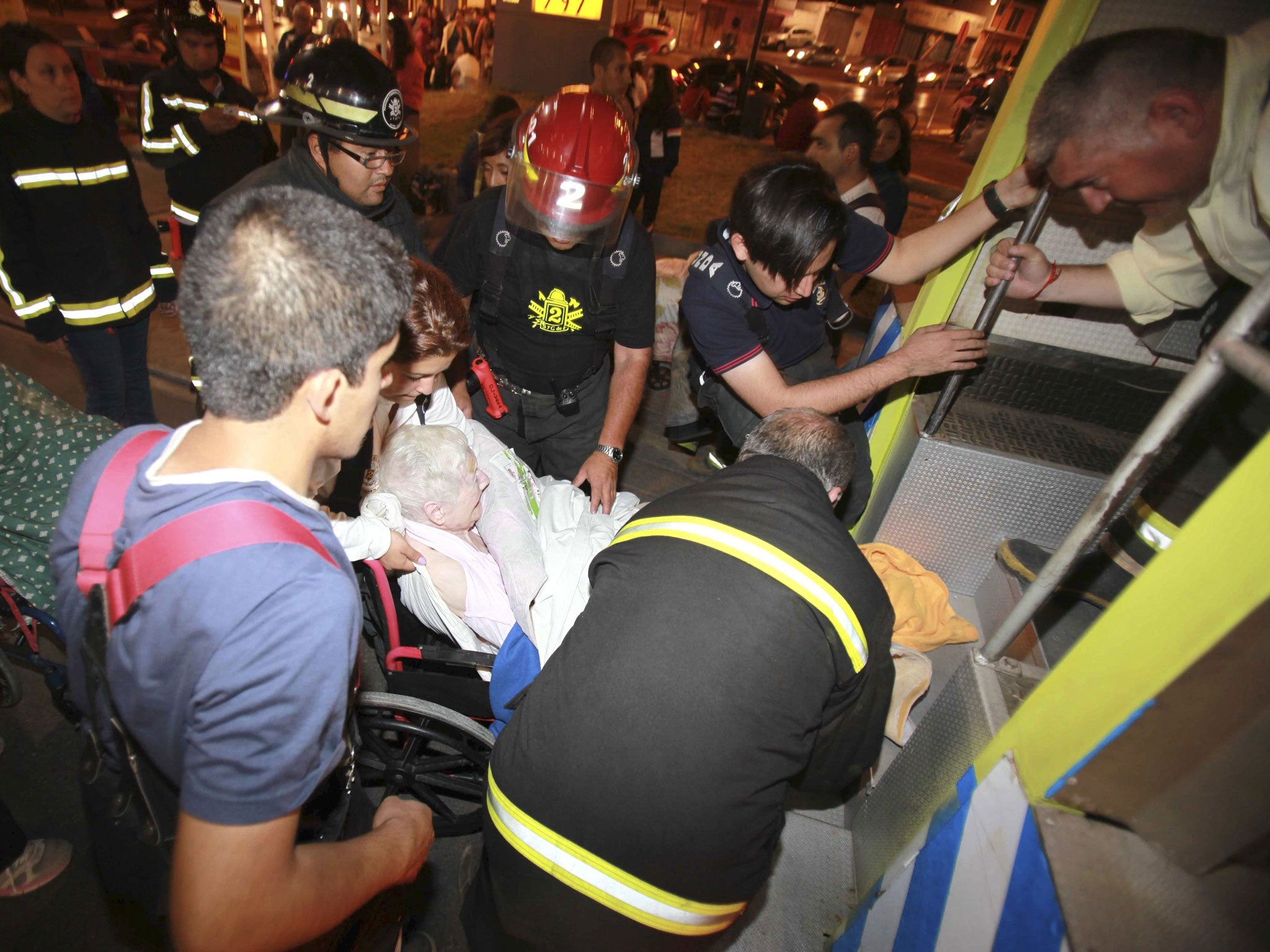 An elderly person is evacuated from a shelter after a tsunami alarm at Antofagasta city on Tuesday, north of Santiago on the southern Pacific coast. The U.S. Geological Survey said the quake was shallow at 12.5 miles below the seabed and struck about 100