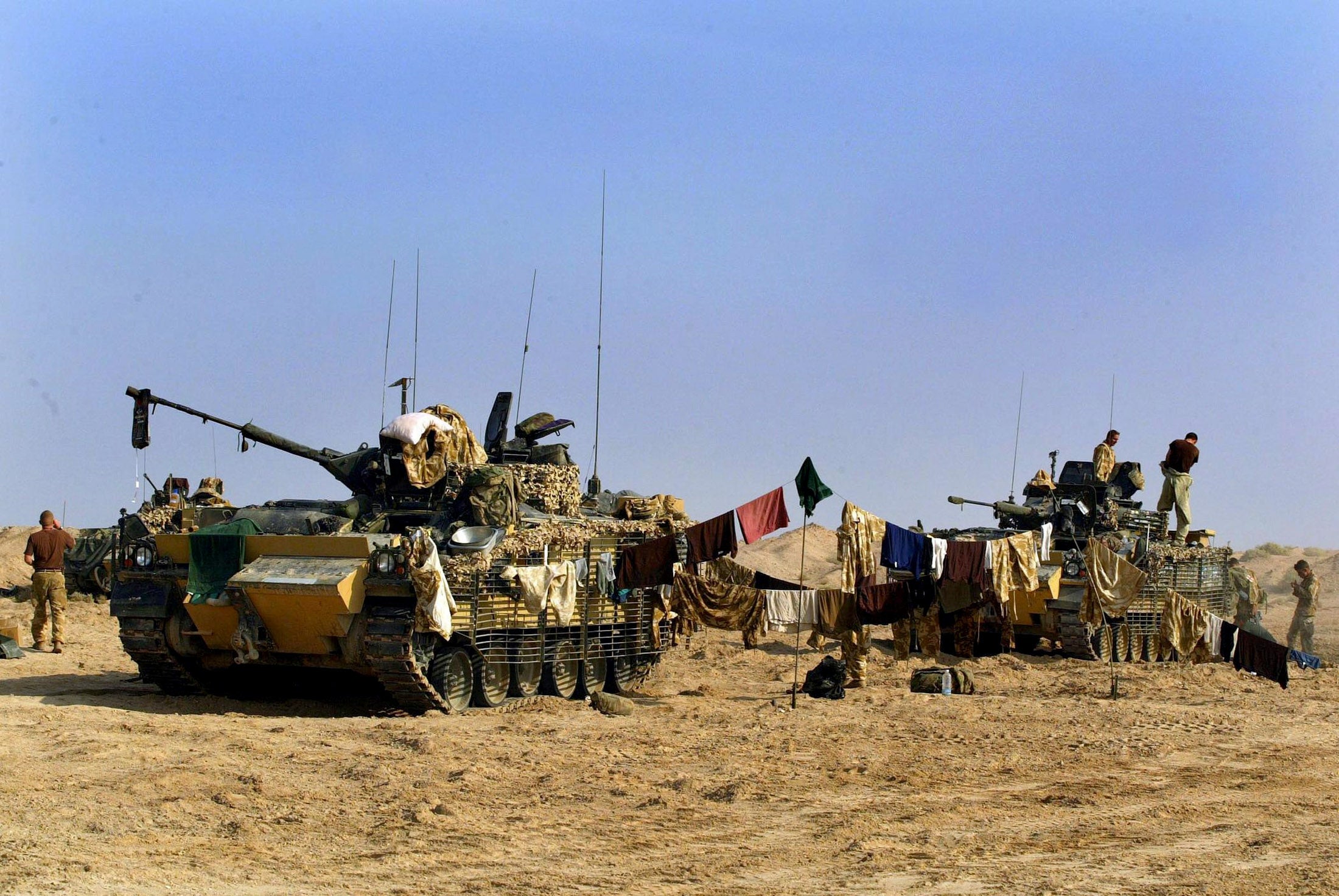 Soldier hang their washing up by two Warrior armoured vehicles in Iraq.