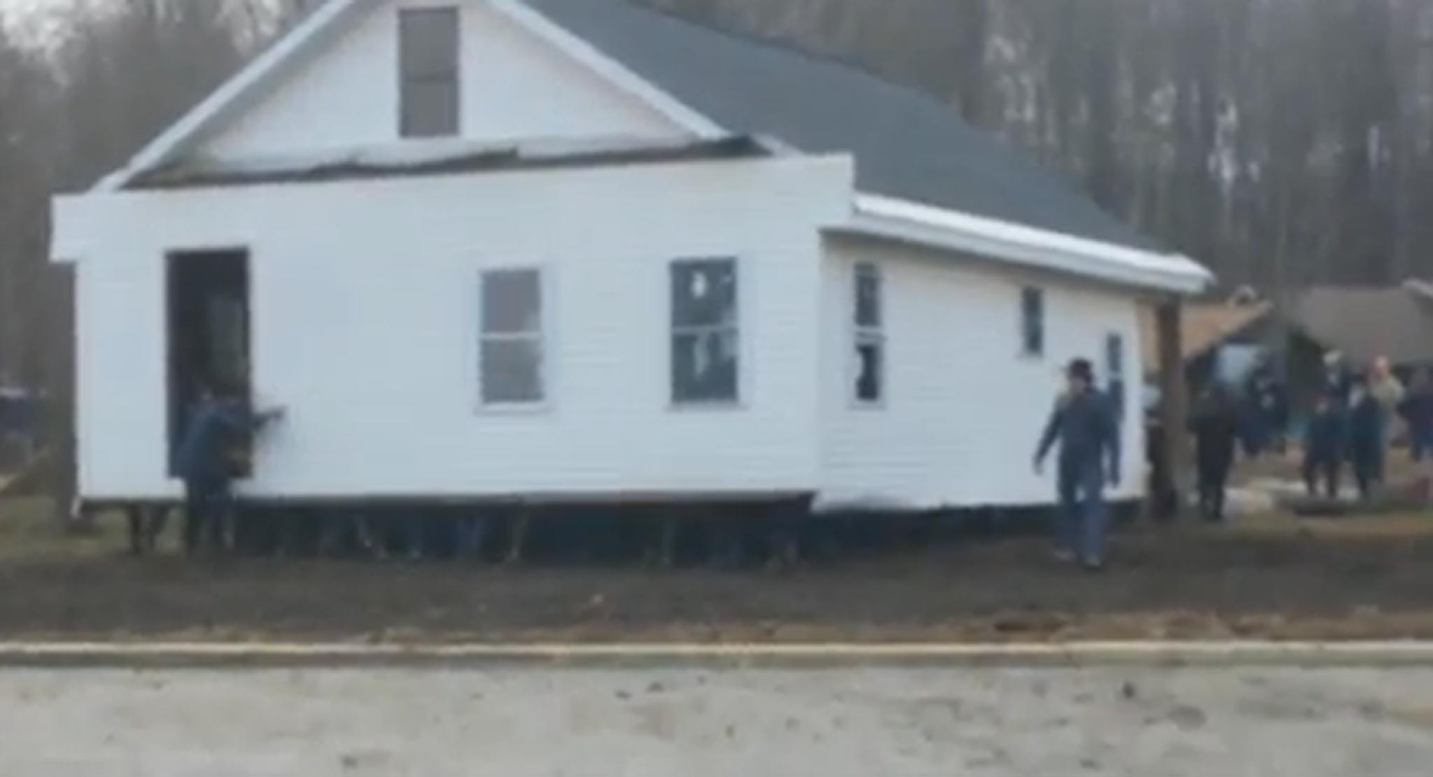 The feet of the people inside the house can be seen at the bottom of walls