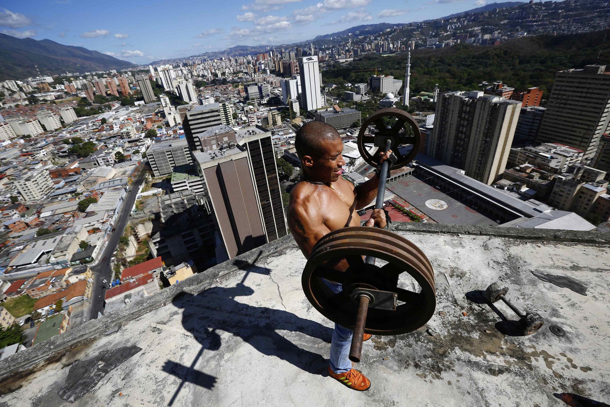 Gabriel Rivas (30) lifts weights on a balcony on the 28th floor of the 'Tower of David' skyscraper in Caracas