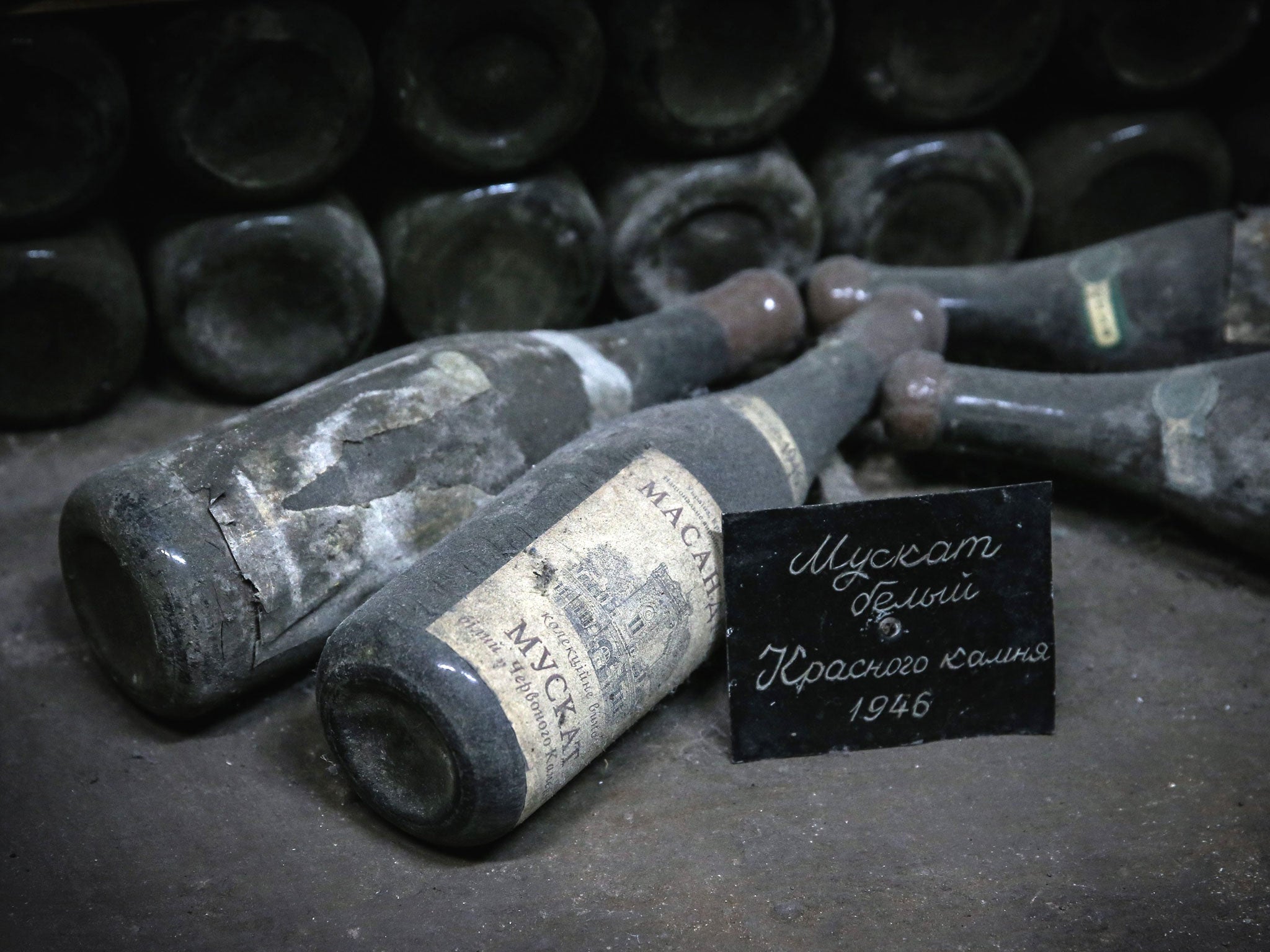 Vintage wine bottles dated from 1946 lay down in the wine cellar of the Massandra winery near Yalta