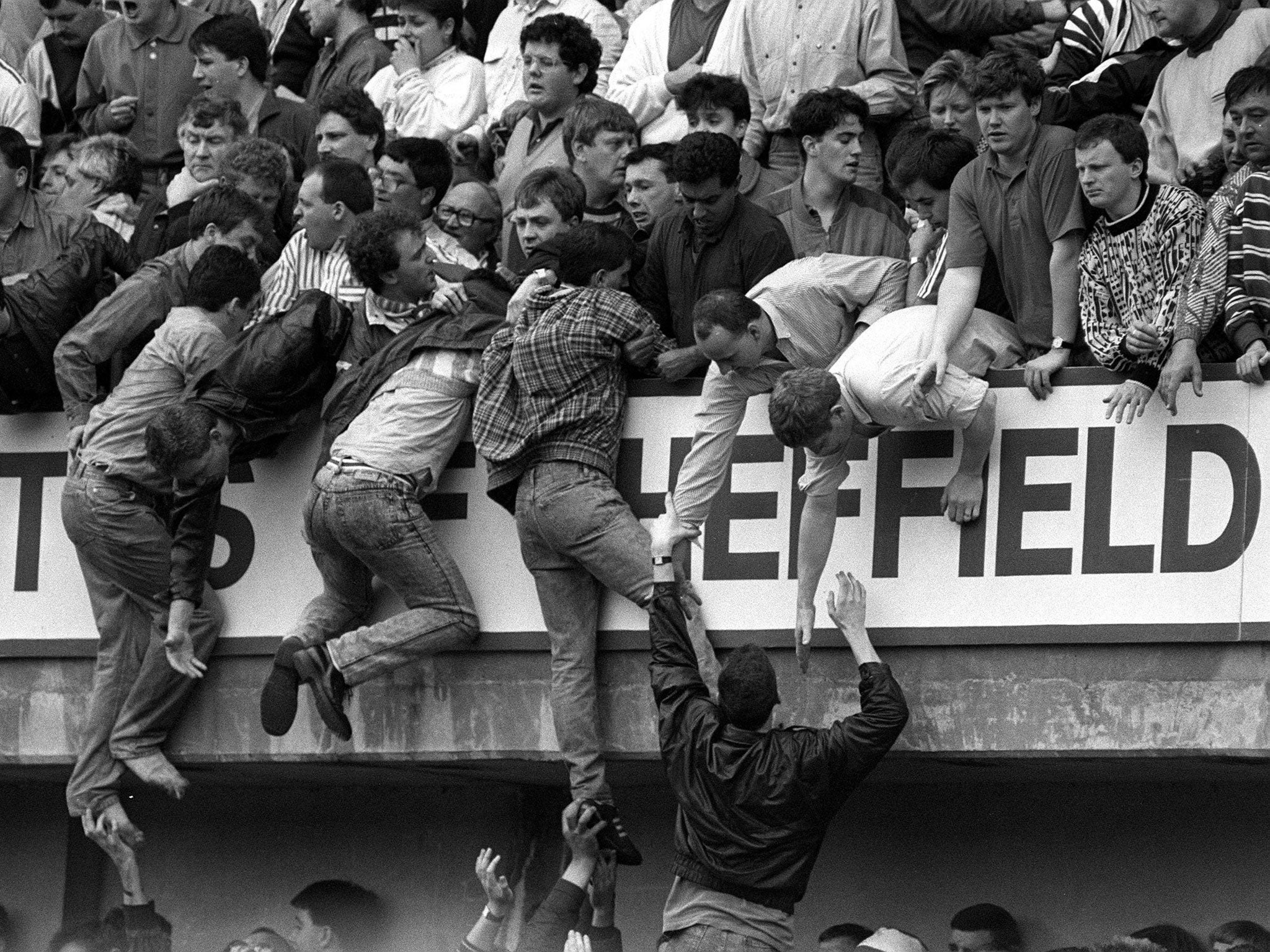 Liverpool fans at Hillsborough try to escape severe overcrowding during the Liverpool vs Nottingham Forest FA Cup semi-final football match on 15 April 1989