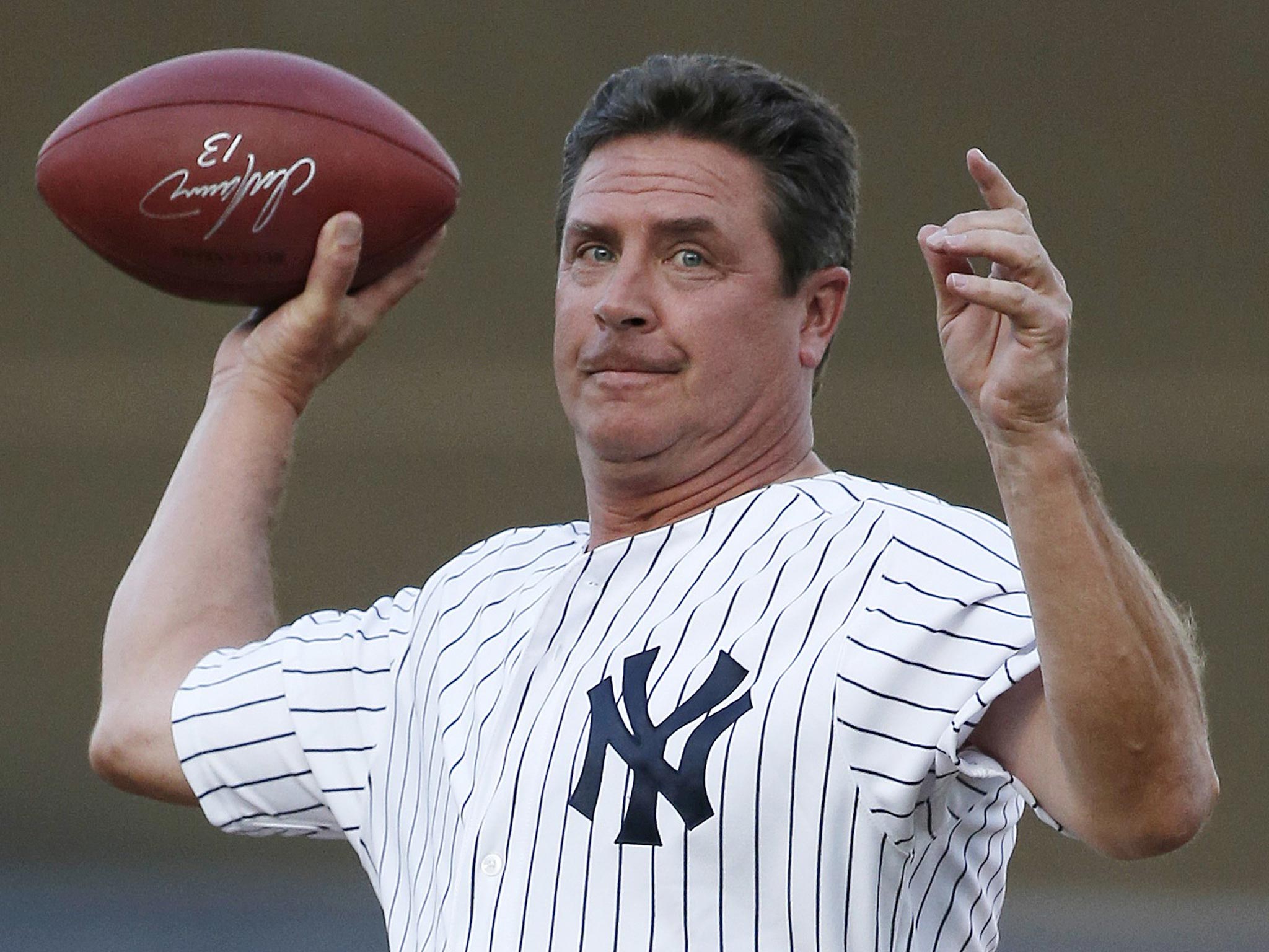 Former Miami Dolphins quarterback Dan Marino throws an autographed football from the mound after throwing out the ceremonial first pitch