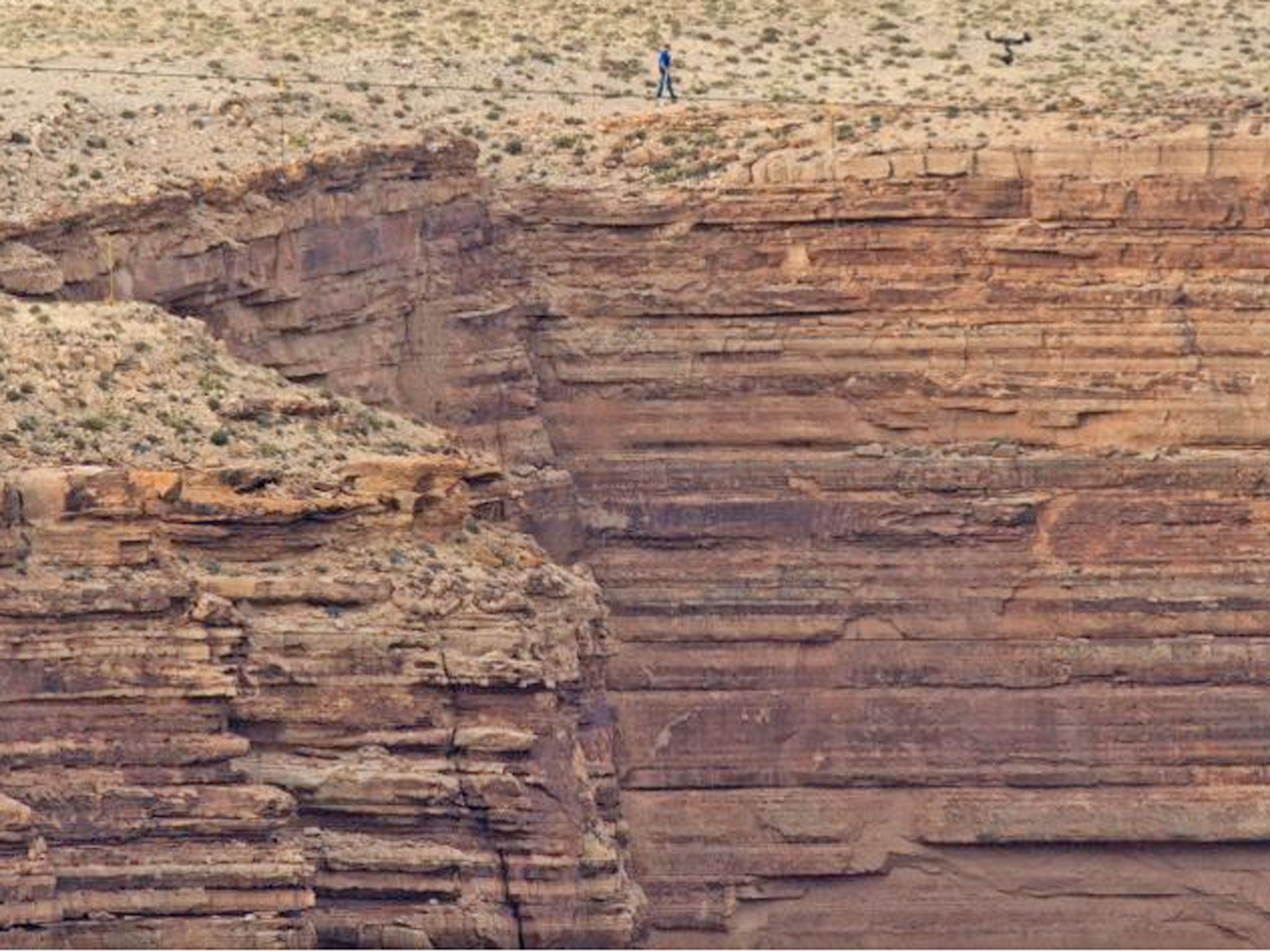 Nik Wallenda (look closely) walks without any harnesses or any safety precautions on a tightrope stretched across the Little Colorado River Gorge near the Grand Canyon on 23 June 2013