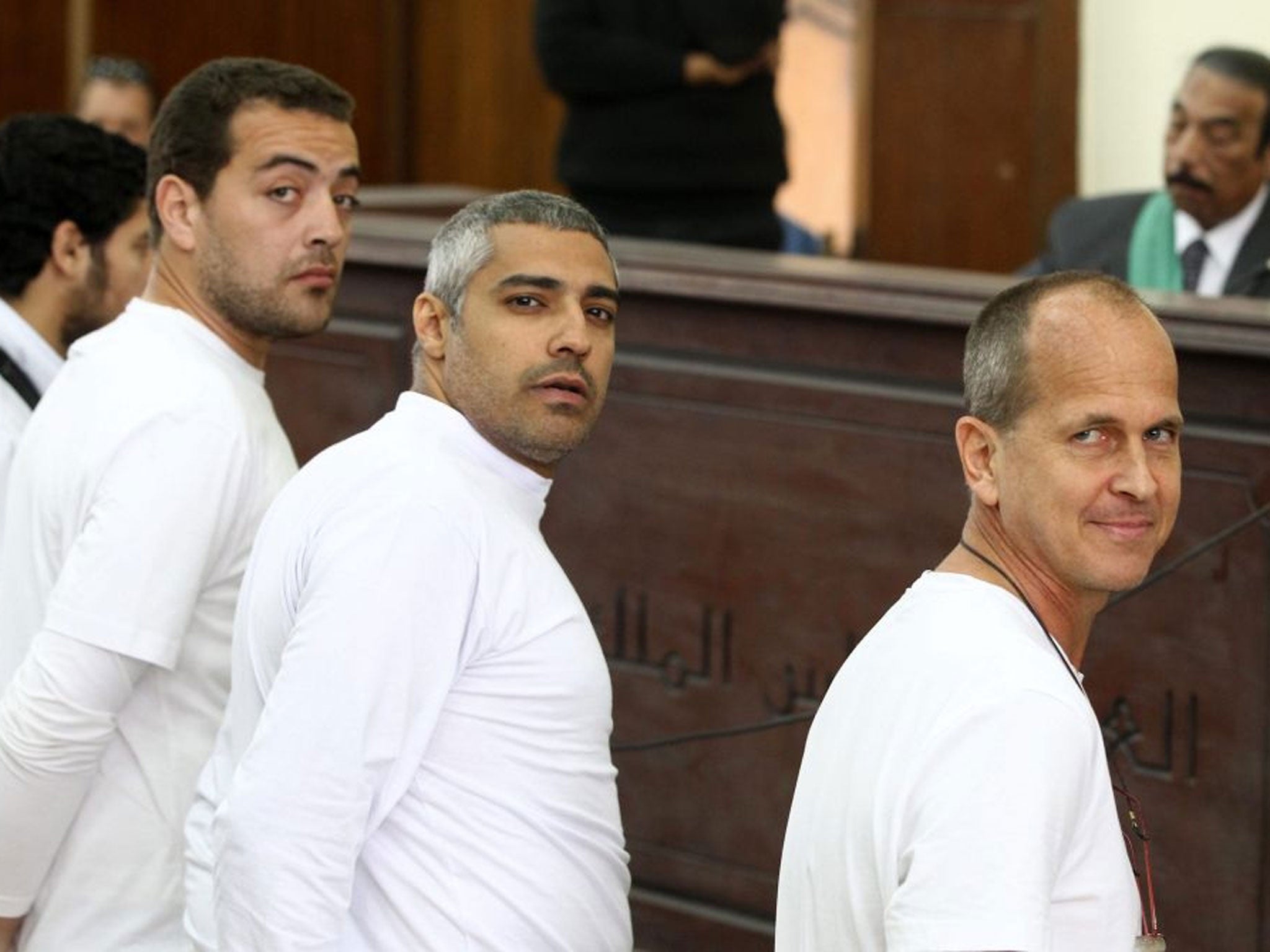 Australian journalist Peter Greste (R), Mohamed Fahmy, Baher Mohamed stand in front of the judge's bench during their trial for allegedly supporting a terrorist group and spreading false information, in Cairo, Egypt, 31 March 2014.