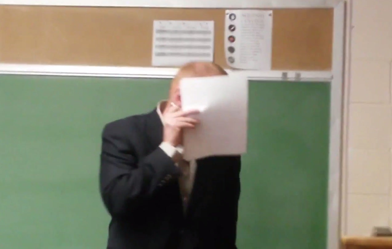 The teacher hides behind his papers