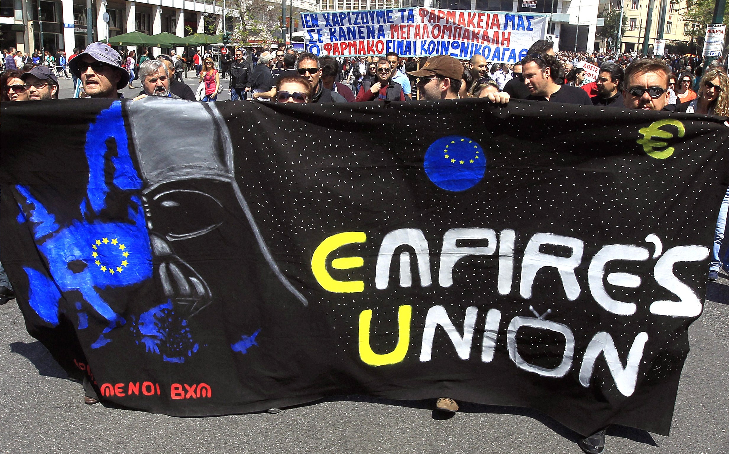 Protesters march outside of the Greek Parliament in Athens