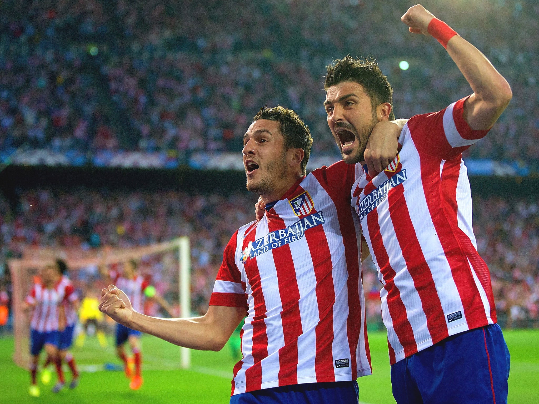 Koke celebrates his goal with former Barcelona striker David Villa