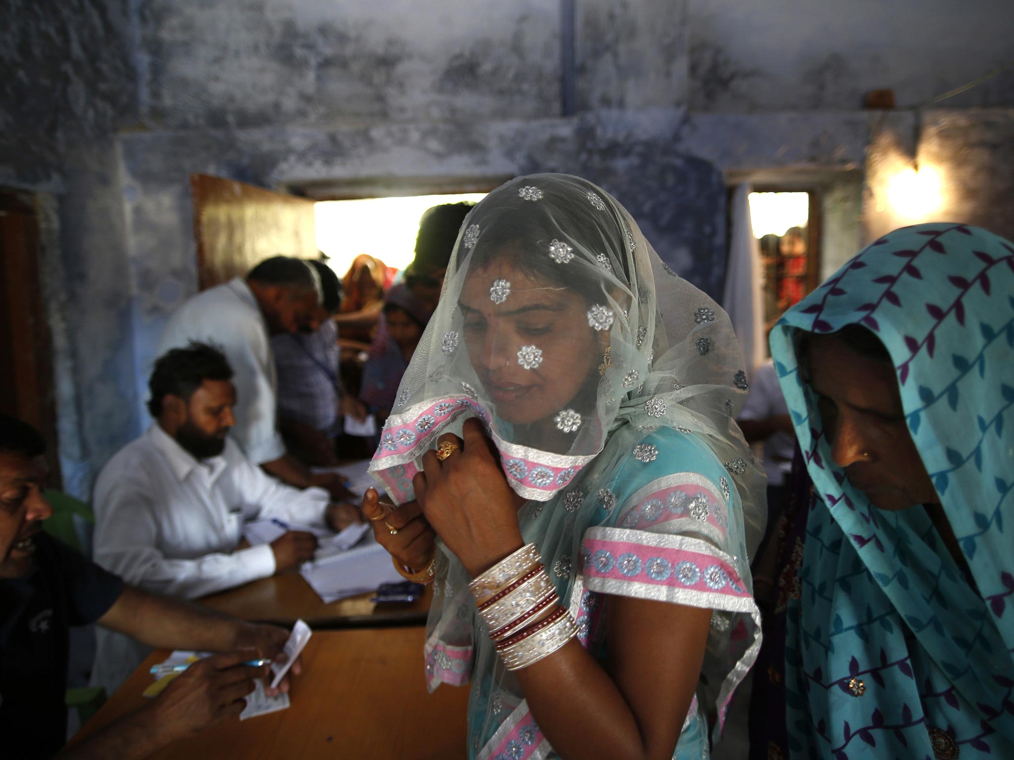 Women wait to cast their ballots in the third phase of India’s elections yesterday, with 91 areas of the capital and 13 other states voting